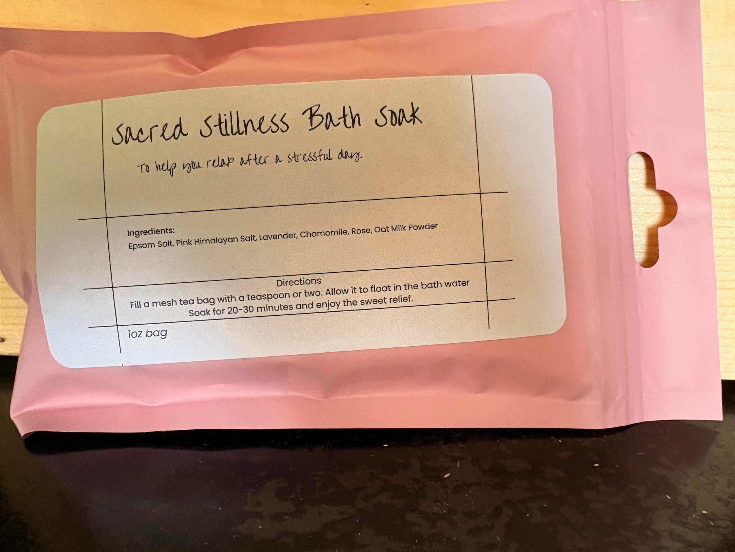Pink package with a white label containing handwritten text and a list of ingredients and directions.
