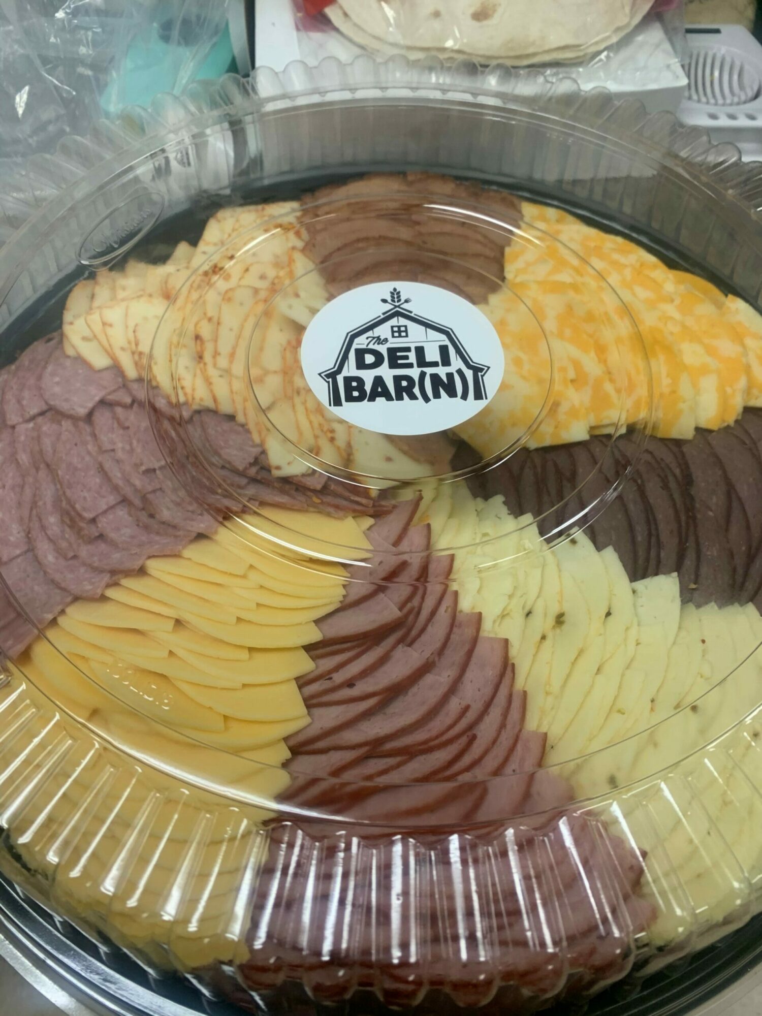 Assorted sliced cheeses and meats arranged on a platter with a label reading 'Benim Baran'.