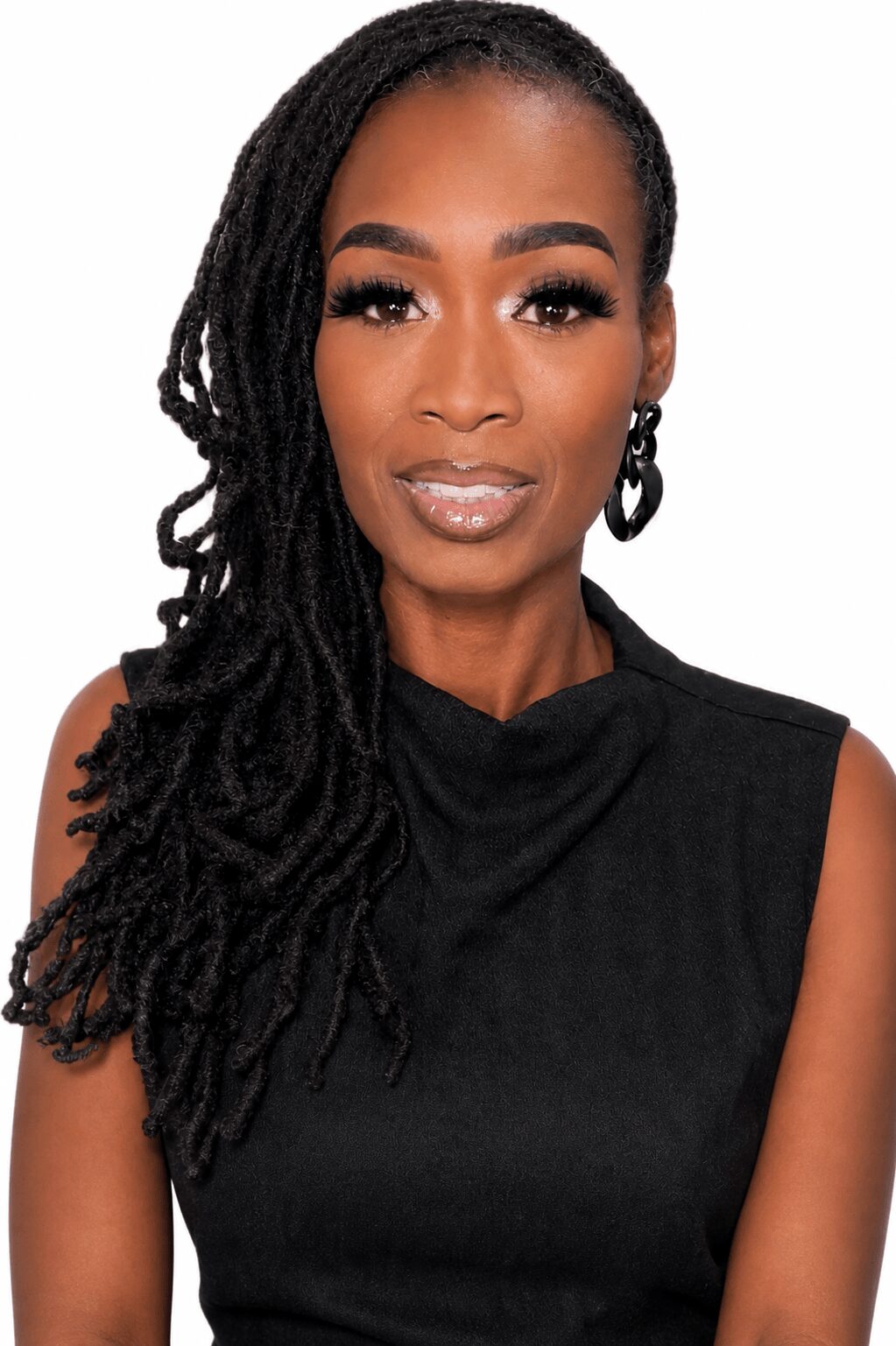Portrait of a woman with long, styled dreadlocks, wearing a sleeveless black top and hoop earrings.