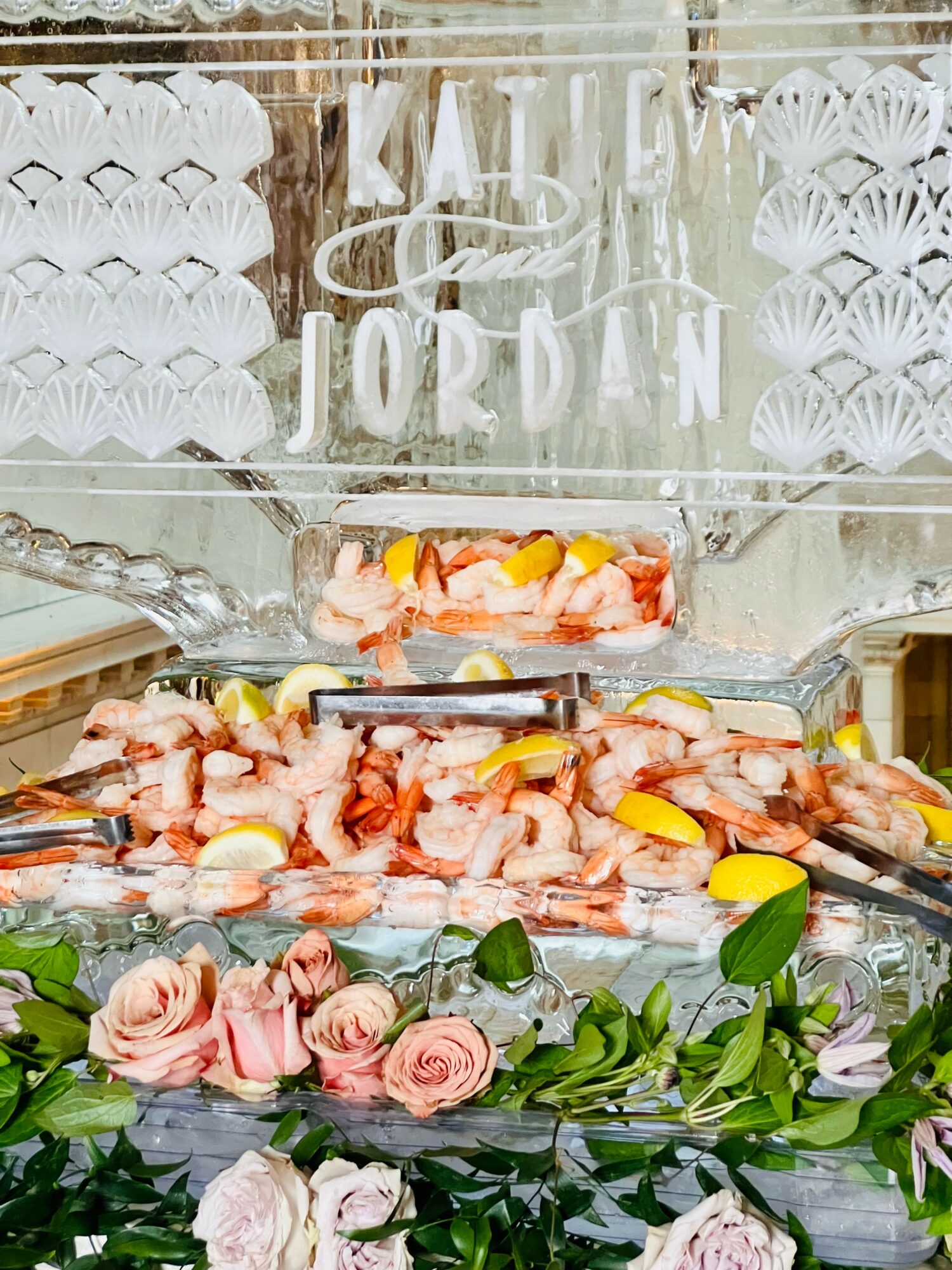 Display of seafood, flowers, and decorative items in a glass container with text on the glass.