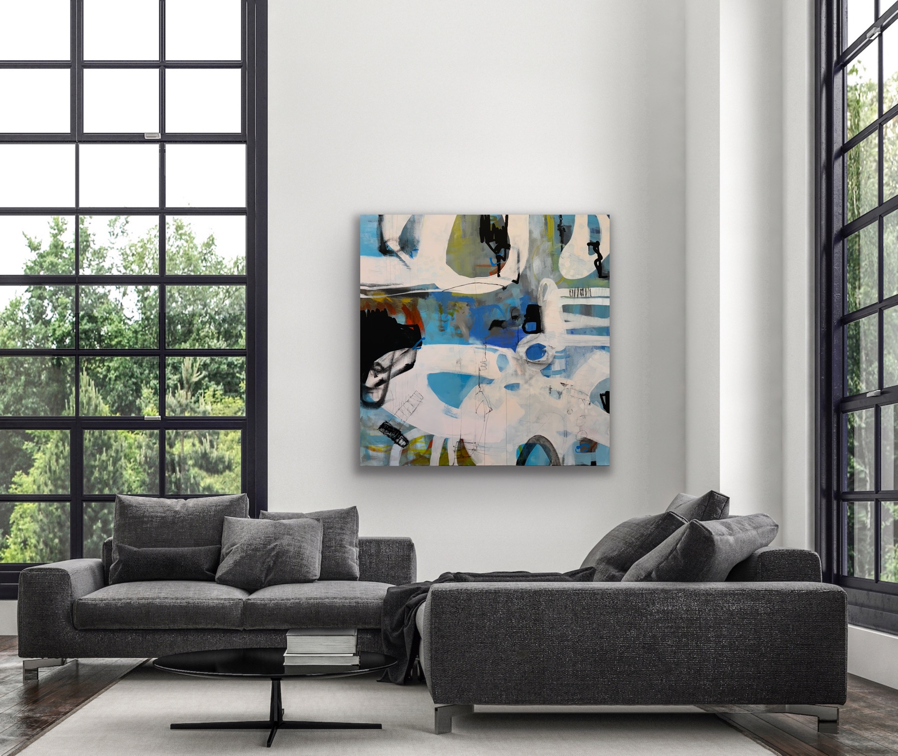 Living room with large windows, a gray sofa, and an abstract painting on the wall.