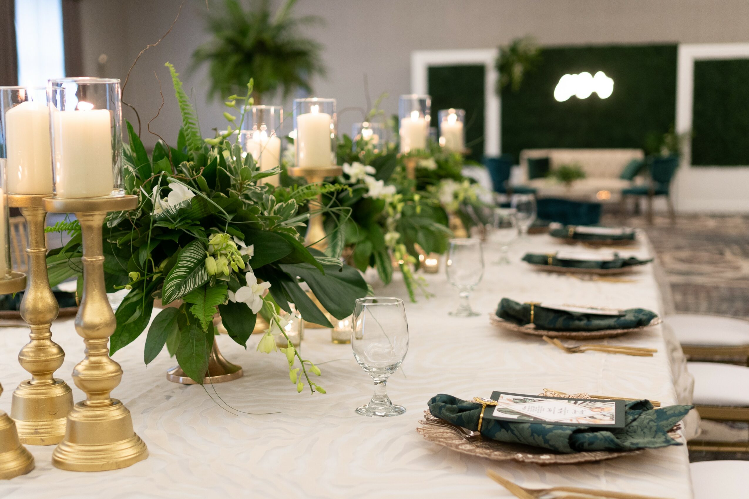 Elegant dining table with floral centerpiece, candles, and place settings in a decorated room.