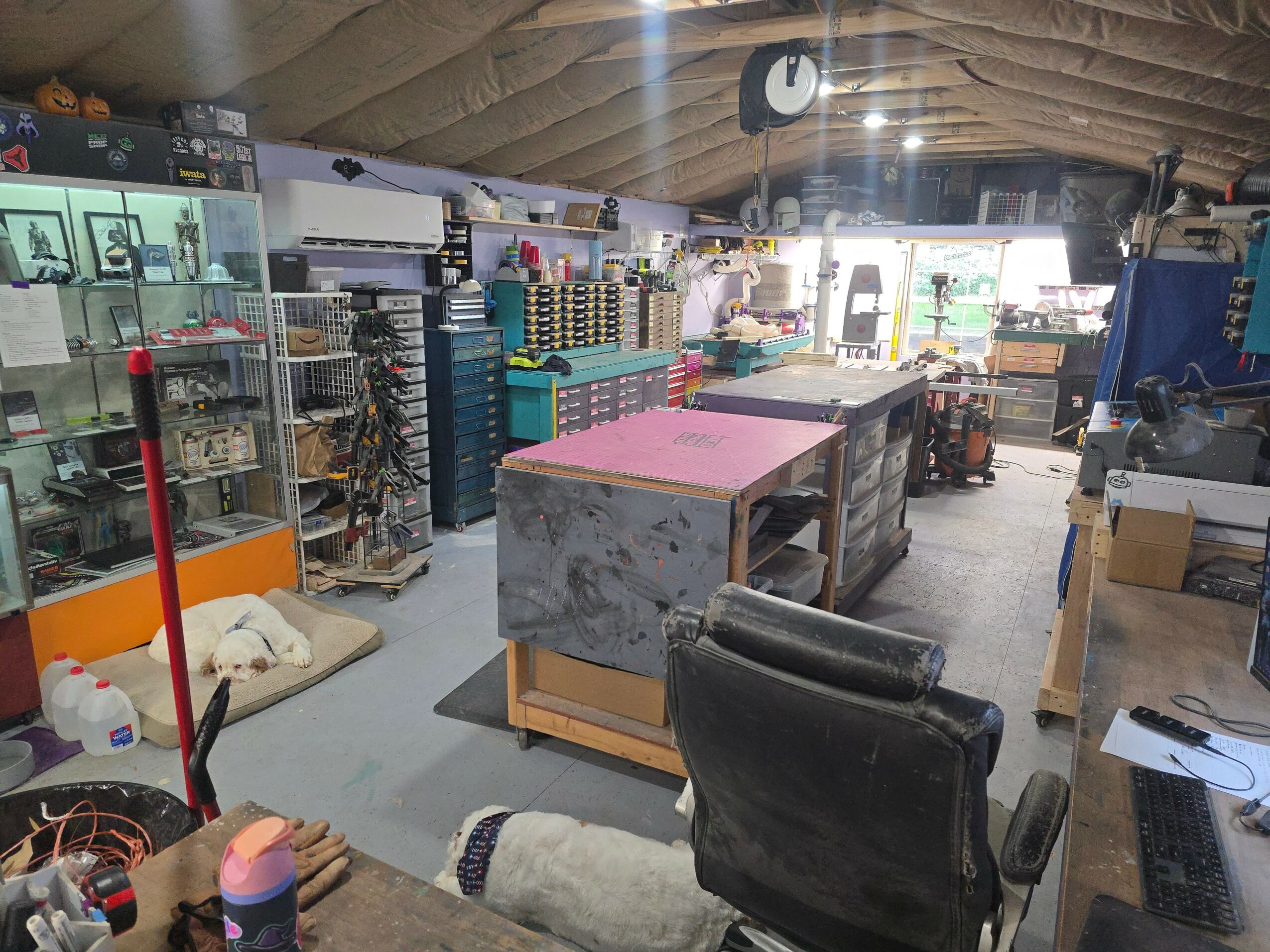 Interior of a store with shelves, counters, and various items, including a black chair in the foreground.