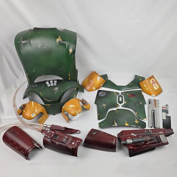 Disassembled green and orange plastic parts, some with scratches, on a white background, resembling a toy or model kit.