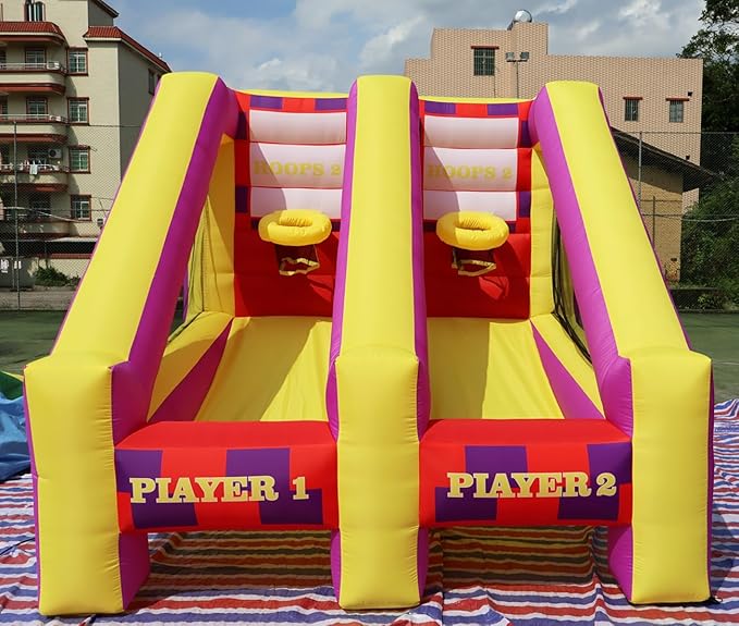 Colorful inflatable dual slide with two lanes, labeled Player 1 and Player 2, set outdoors on a striped rug.
