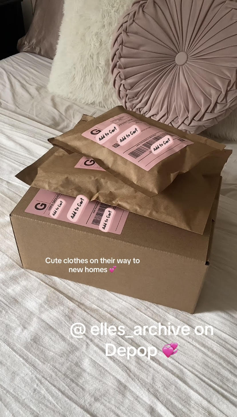 Three pink clothing packages on a bed with pillows, one in a box, with a caption about new clothes and a pink heart emoji.