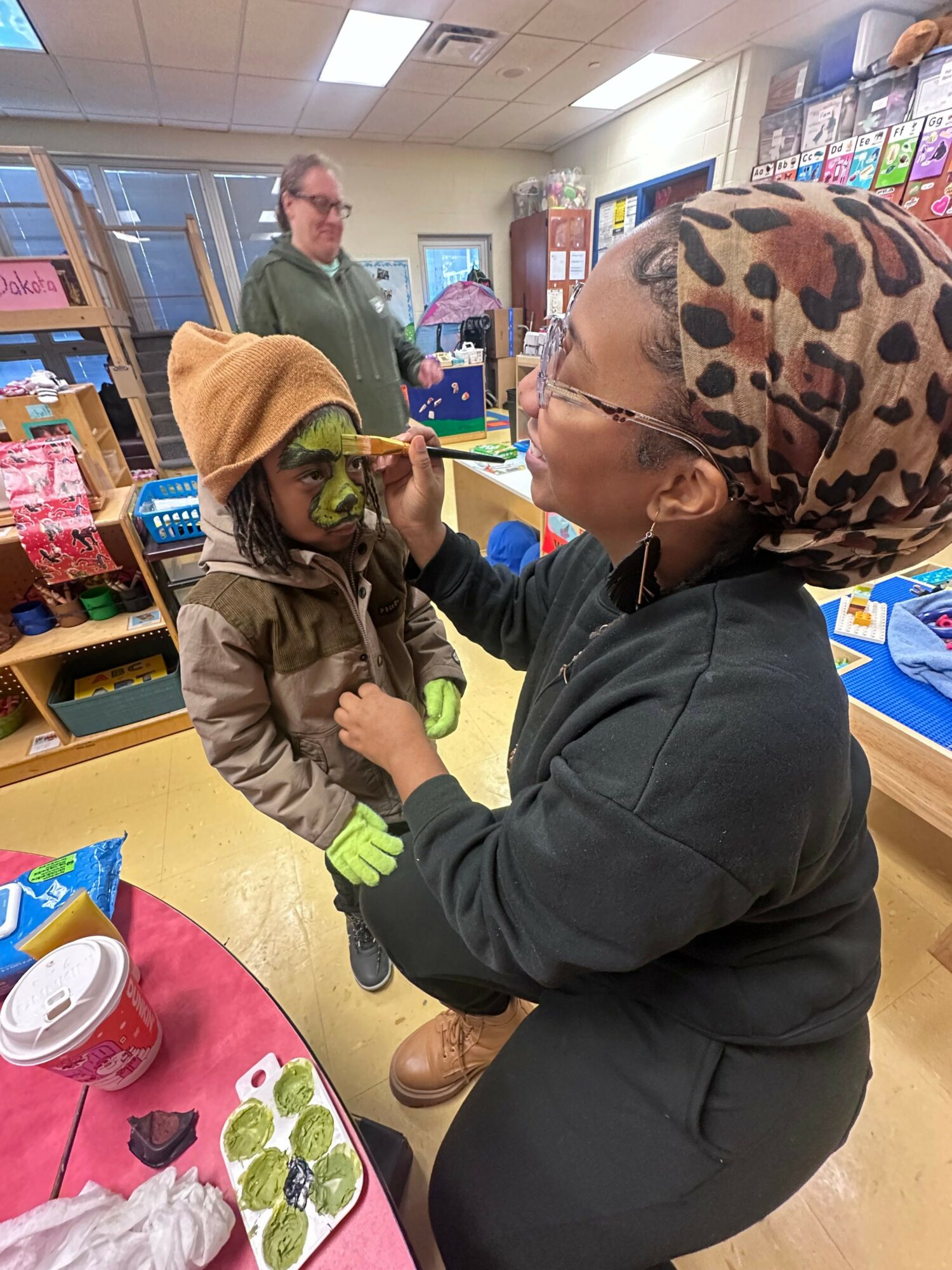 Woman and child interacting in a store, with shelves and products visible in the background.