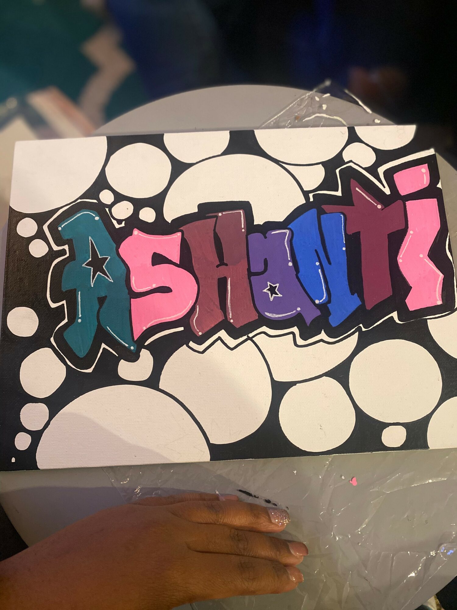 Colorful graffiti-style text spelling 'SHOUT' on a black and white bubble background.