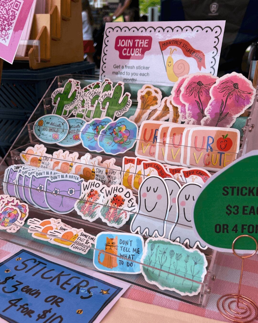 Display of colorful stickers with various designs, including animals, flowers, and text, on a store shelf.