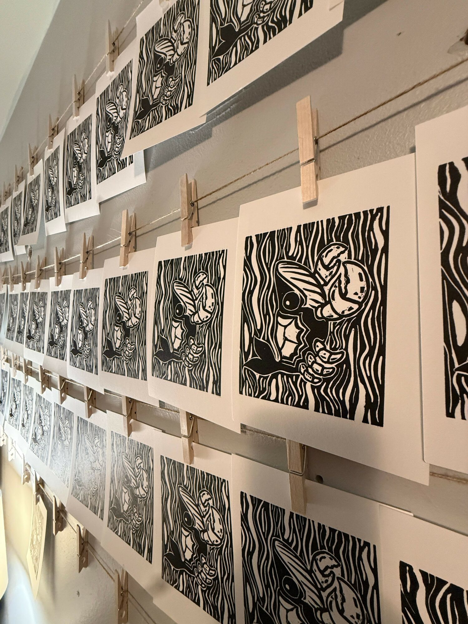 Ceiling with black and white illustrations of fish and aquatic scenes, arranged in a grid pattern.