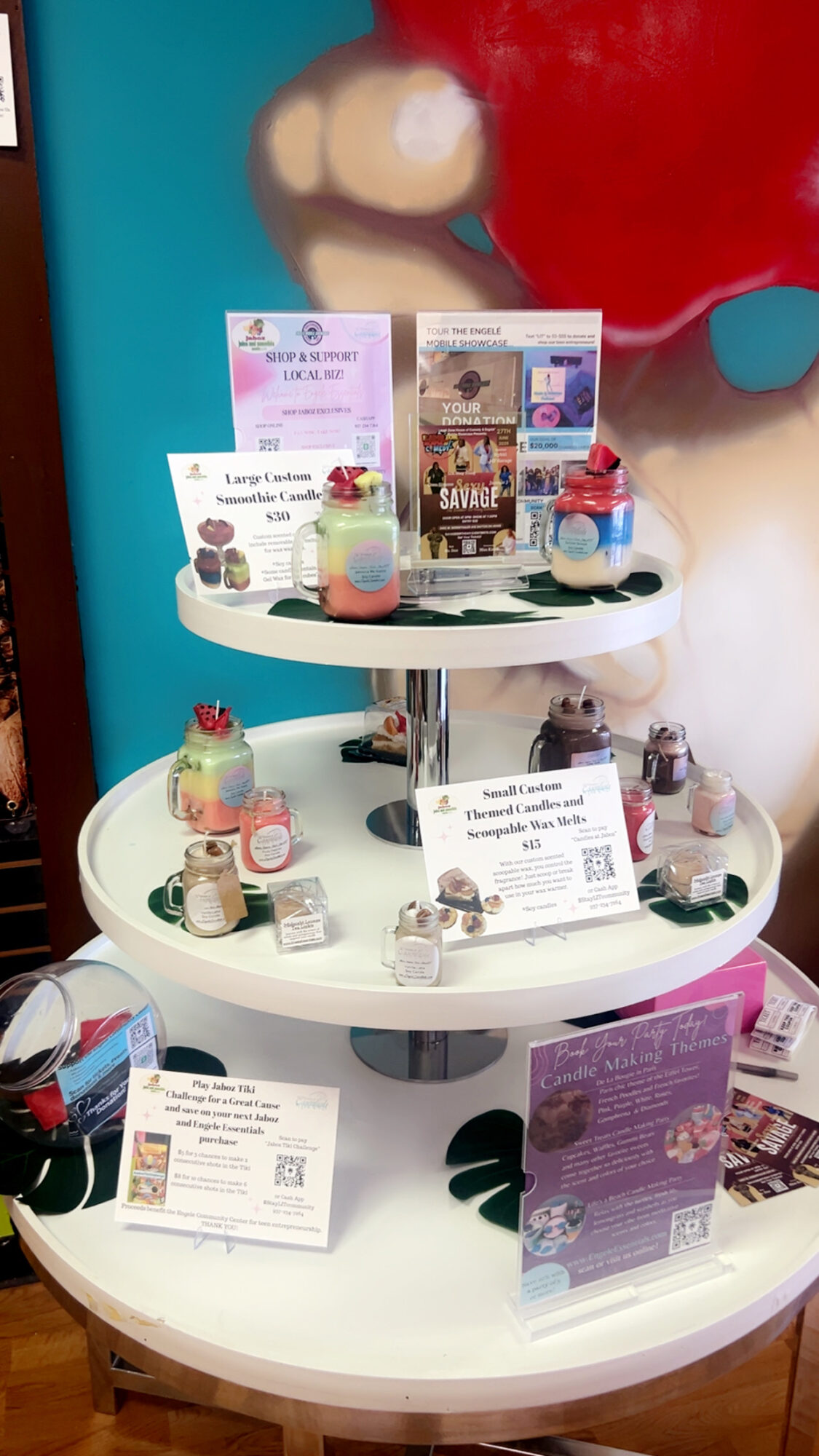 Display stand with colorful small items and informational cards, set against a vibrant background with a large face illustration.