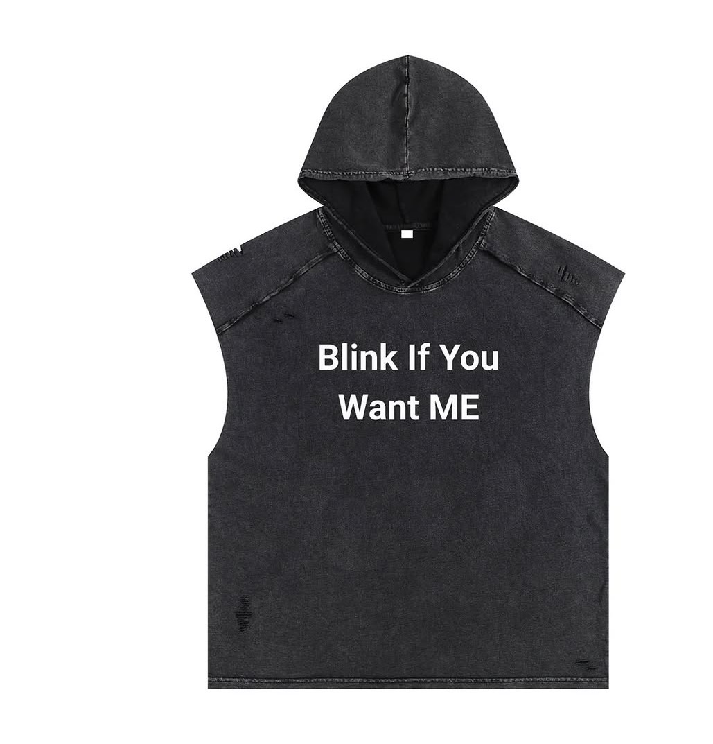 Black sleeveless hoodie with text 'Blink If You Want ME' on front, hood up, plain background.
