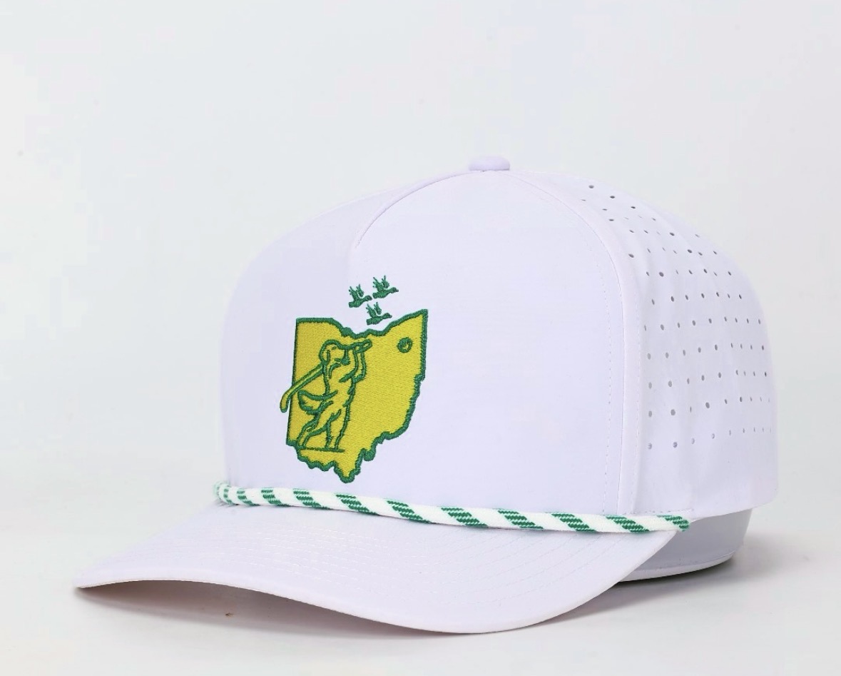 White baseball cap with green and yellow embroidered logo, green striped brim, and perforated side panels.