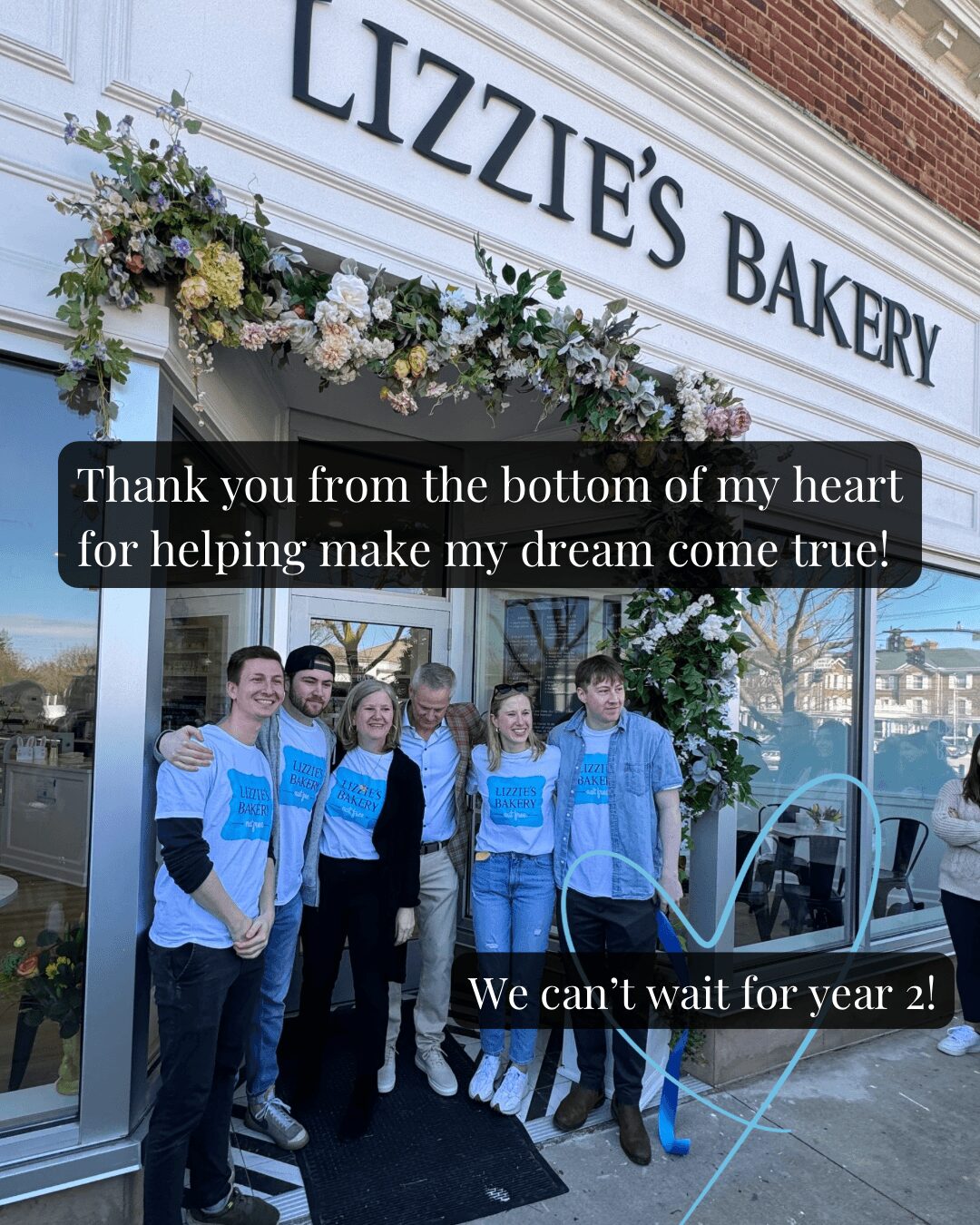 Group of six people standing outside Lizzie's Bakery, smiling, with a floral decoration above the entrance, and a message overlay.