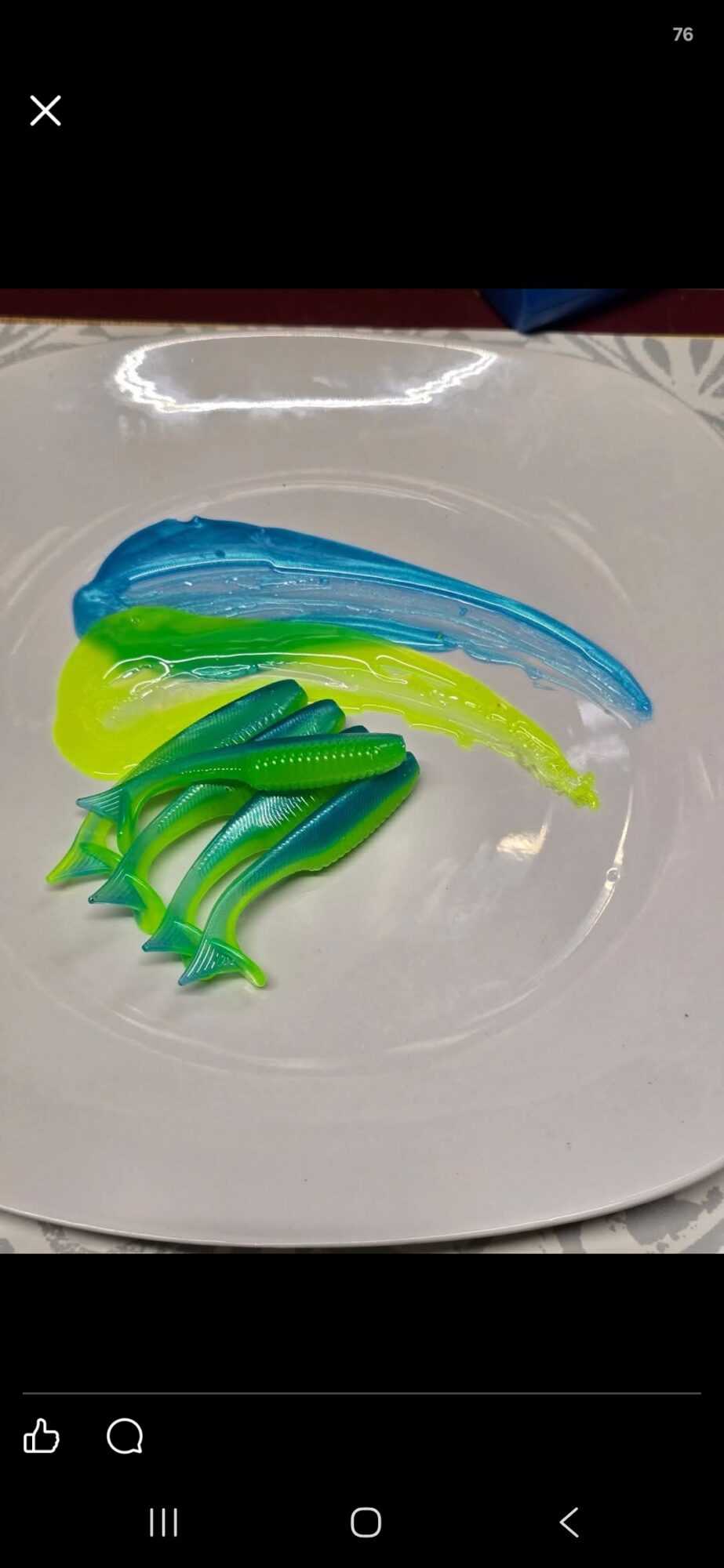 Colorful plastic hair clips on a white plate, with blue, green, and yellow clips arranged in a row.