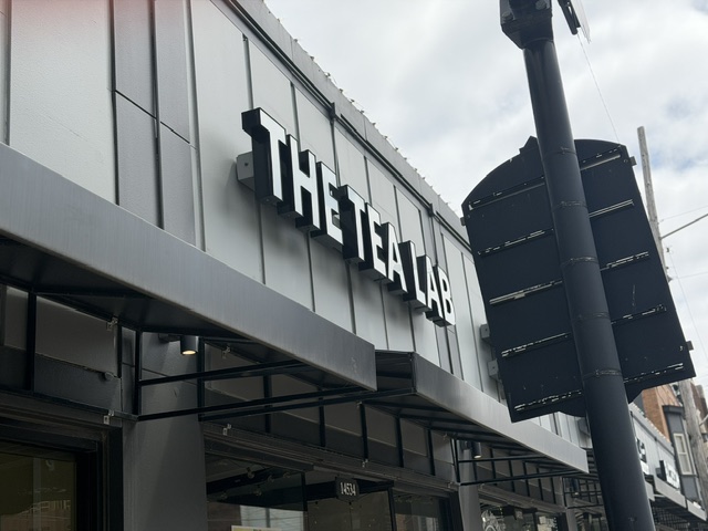 The theater's exterior with a sign reading 'THE THEATRE LAB' on a modern building facade.