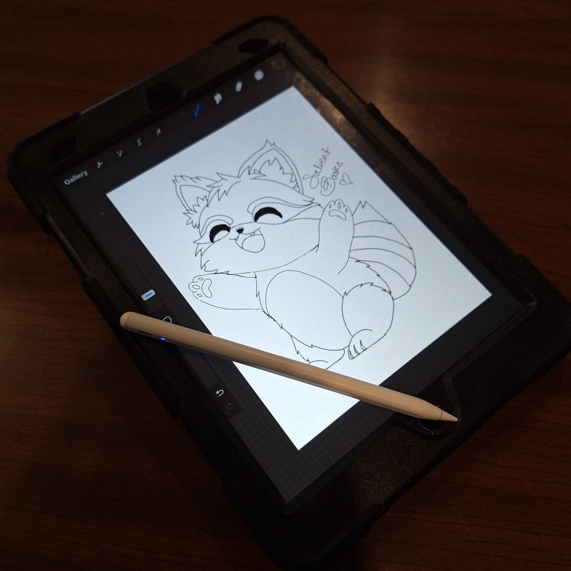 Drawing of a happy, cartoon-style cat with closed eyes, sitting with one paw raised, on a digital tablet with stylus.