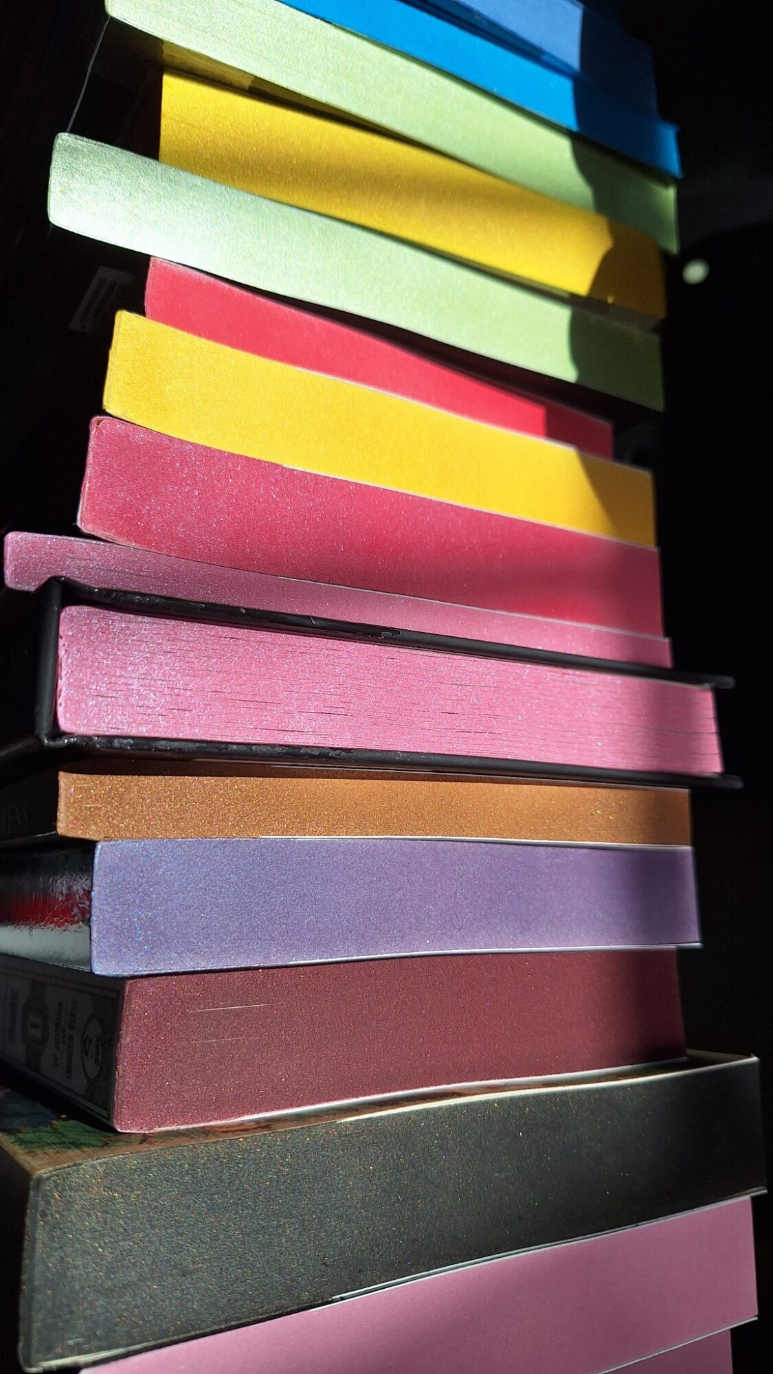 Stack of colorful chalk sticks arranged vertically, with various colors including yellow, pink, green, blue, and purple.