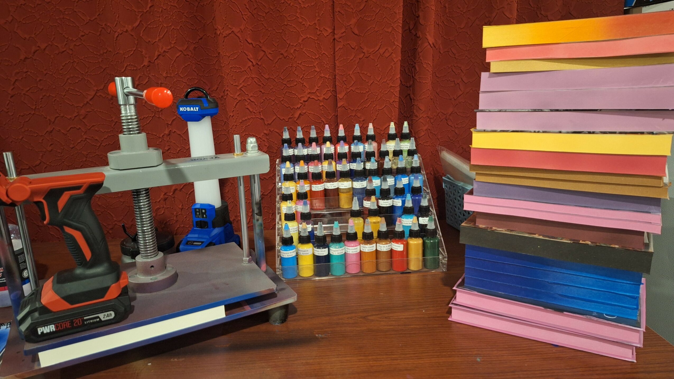 Laboratory setup with a microscope, test tubes, and stacked colorful paper or cardboard sheets on a wooden surface.