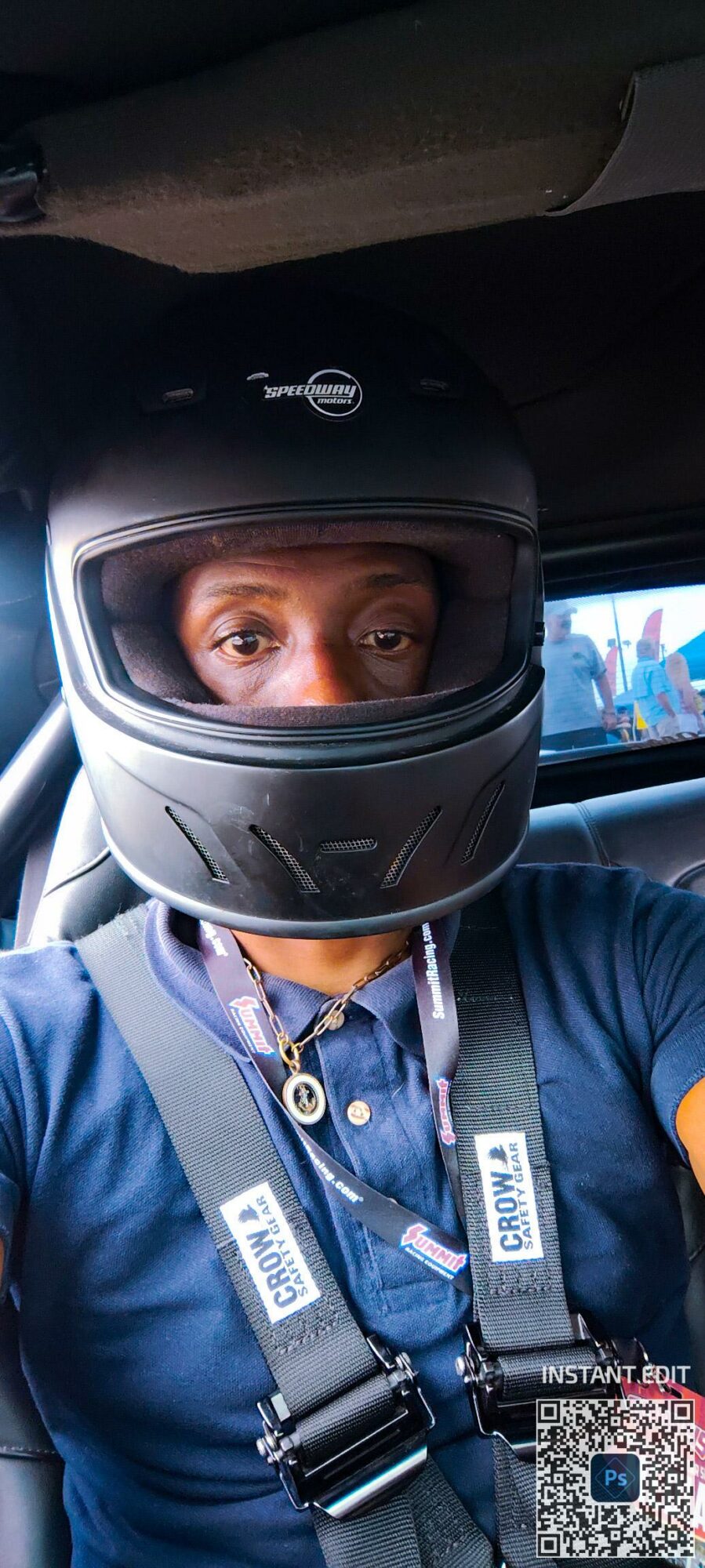 Person wearing a motorcycle helmet and blue shirt, sitting in a vehicle, with eyes visible through the helmet's visor.