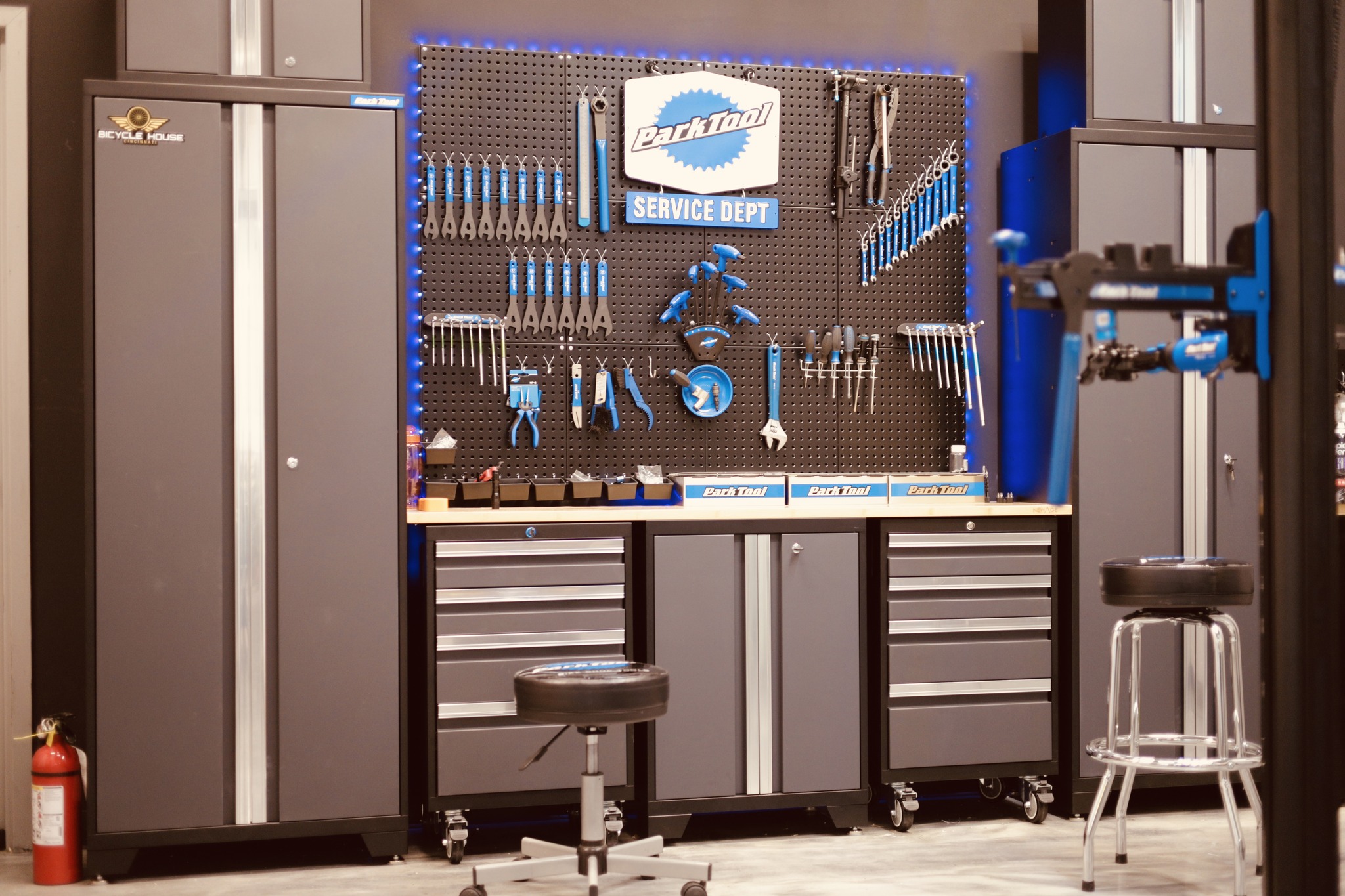 Workshop with tools on a pegboard, workbenches, and stools, in a service or repair area.