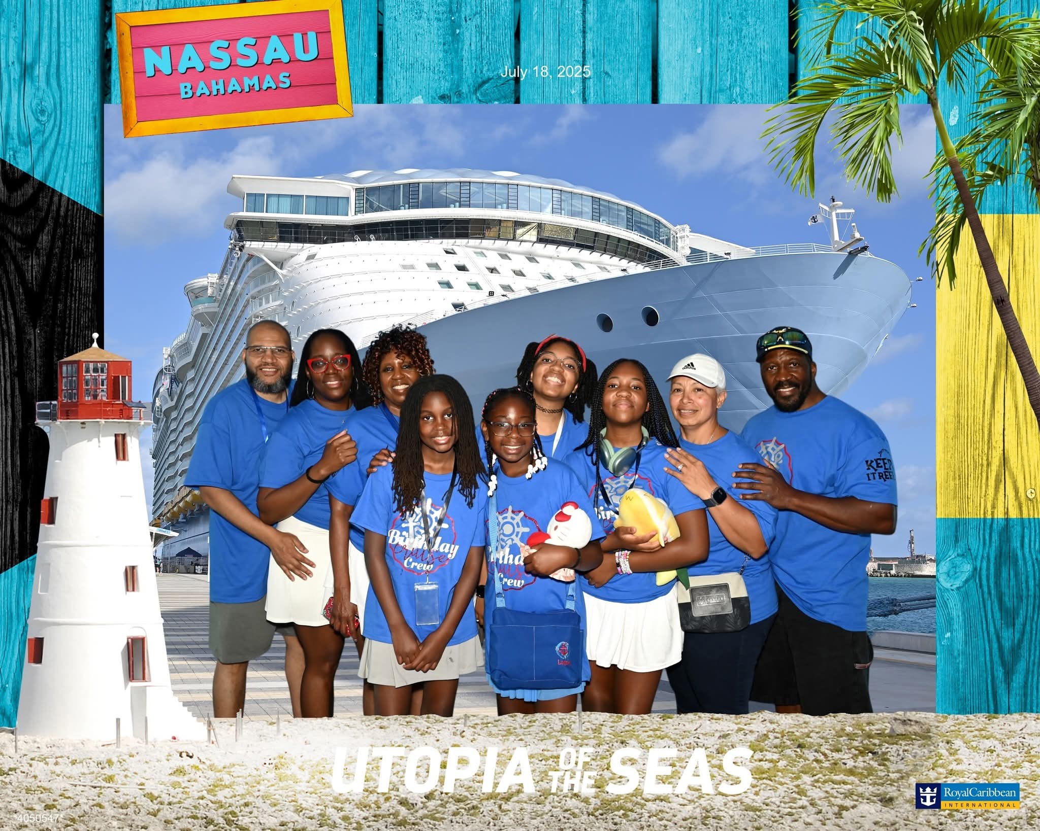 Group of people in blue shirts standing on beach with cruise ship, lighthouse, and palm trees in background.