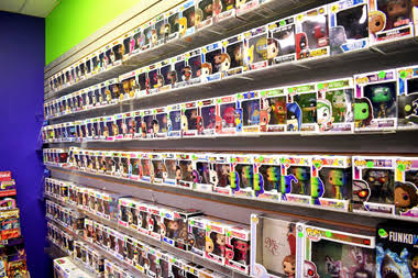 Shelves filled with colorful Funko Pop! figures in a store, arranged in rows and columns, with bright lighting.