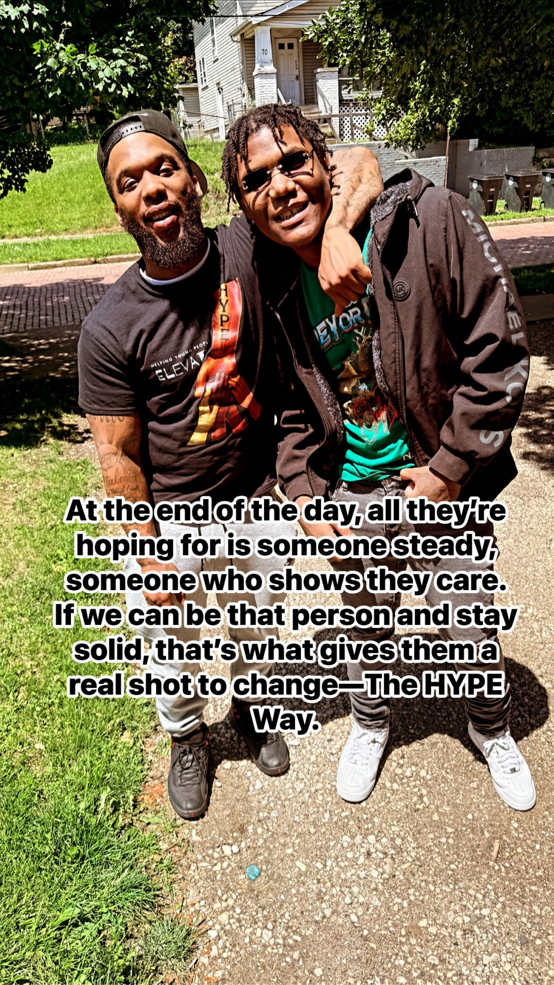 Two young men standing outdoors on a sunny day, smiling, with trees and a building in the background. Text overlay about hope and change.
