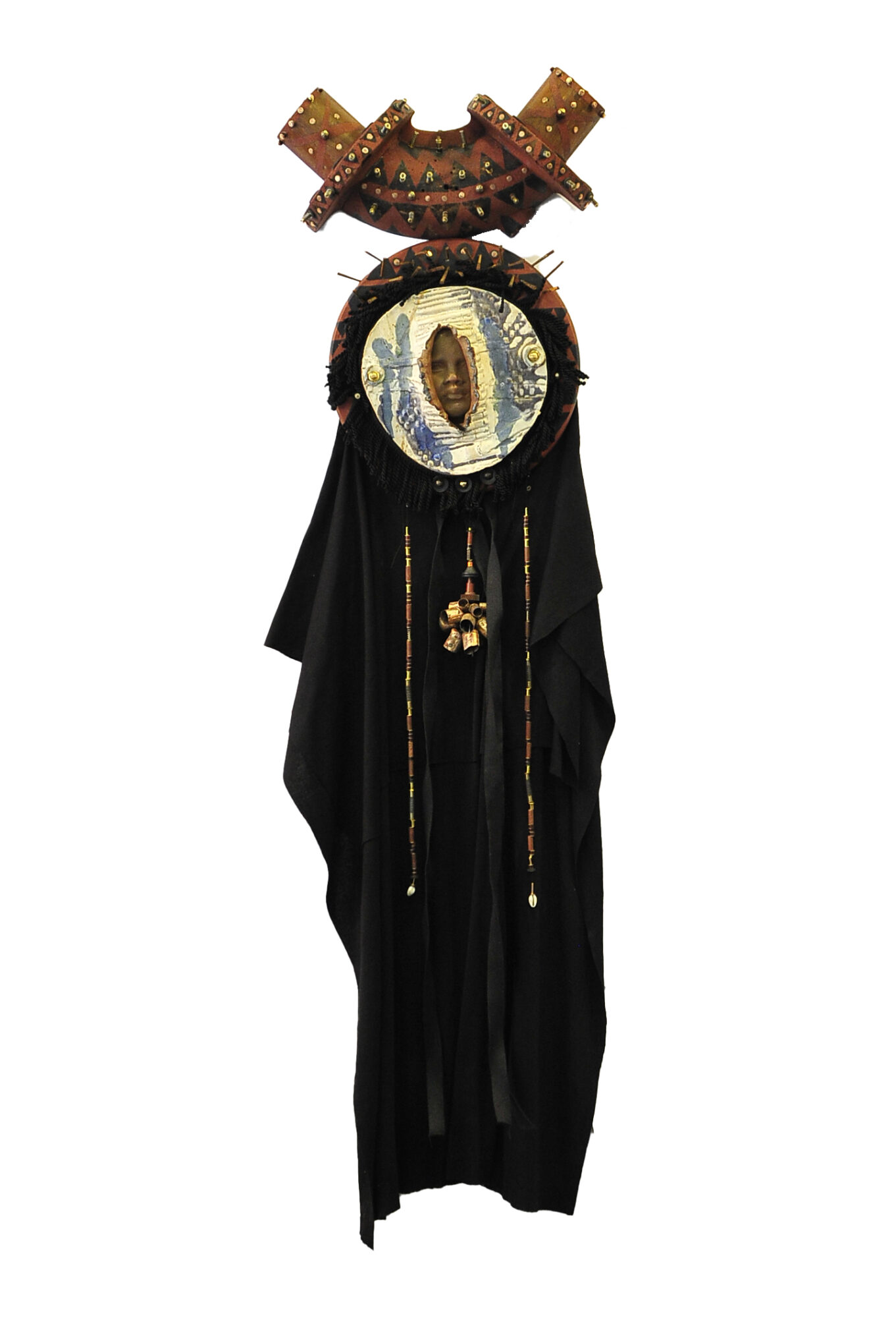 Decorative figure with a circular face, black clothing, and an ornate headpiece with geometric patterns.