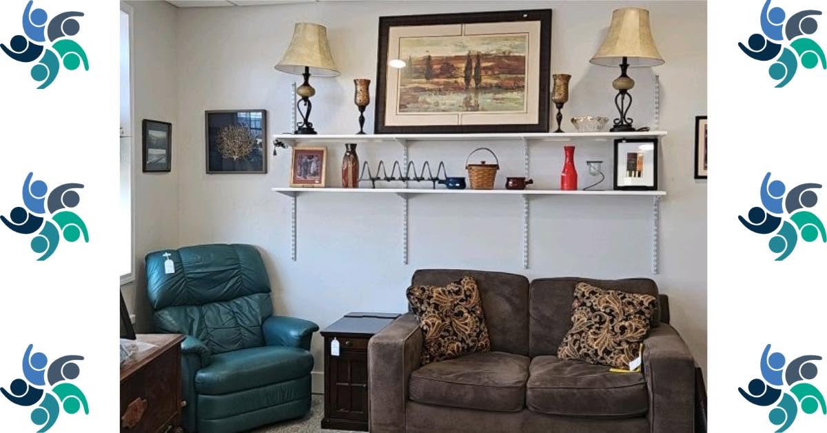 Living room with two sofas, wall shelf with decorations, framed picture, and lamps, arranged against a white wall.