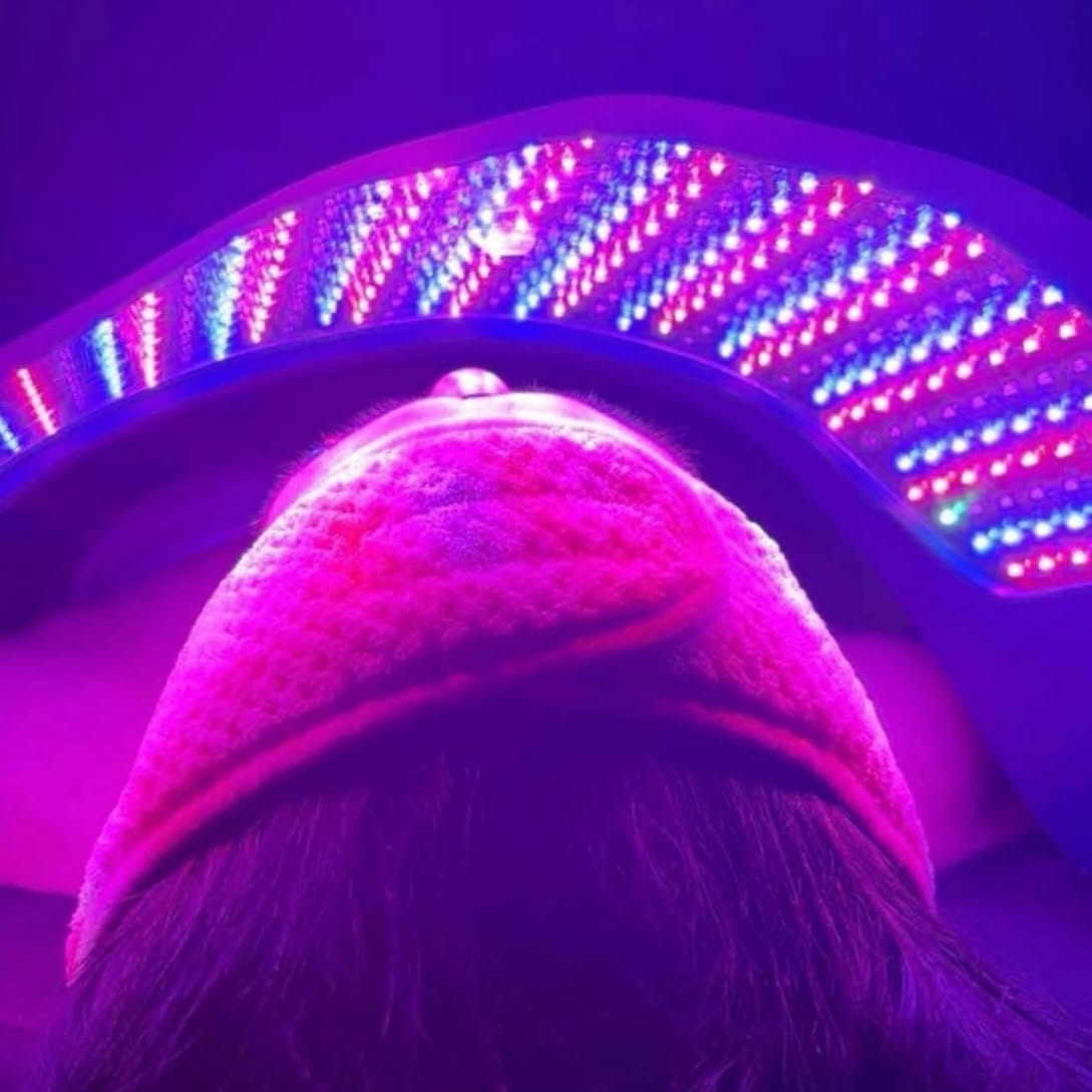Person wearing a pink hat with colorful LED lights in the background, viewed from above.