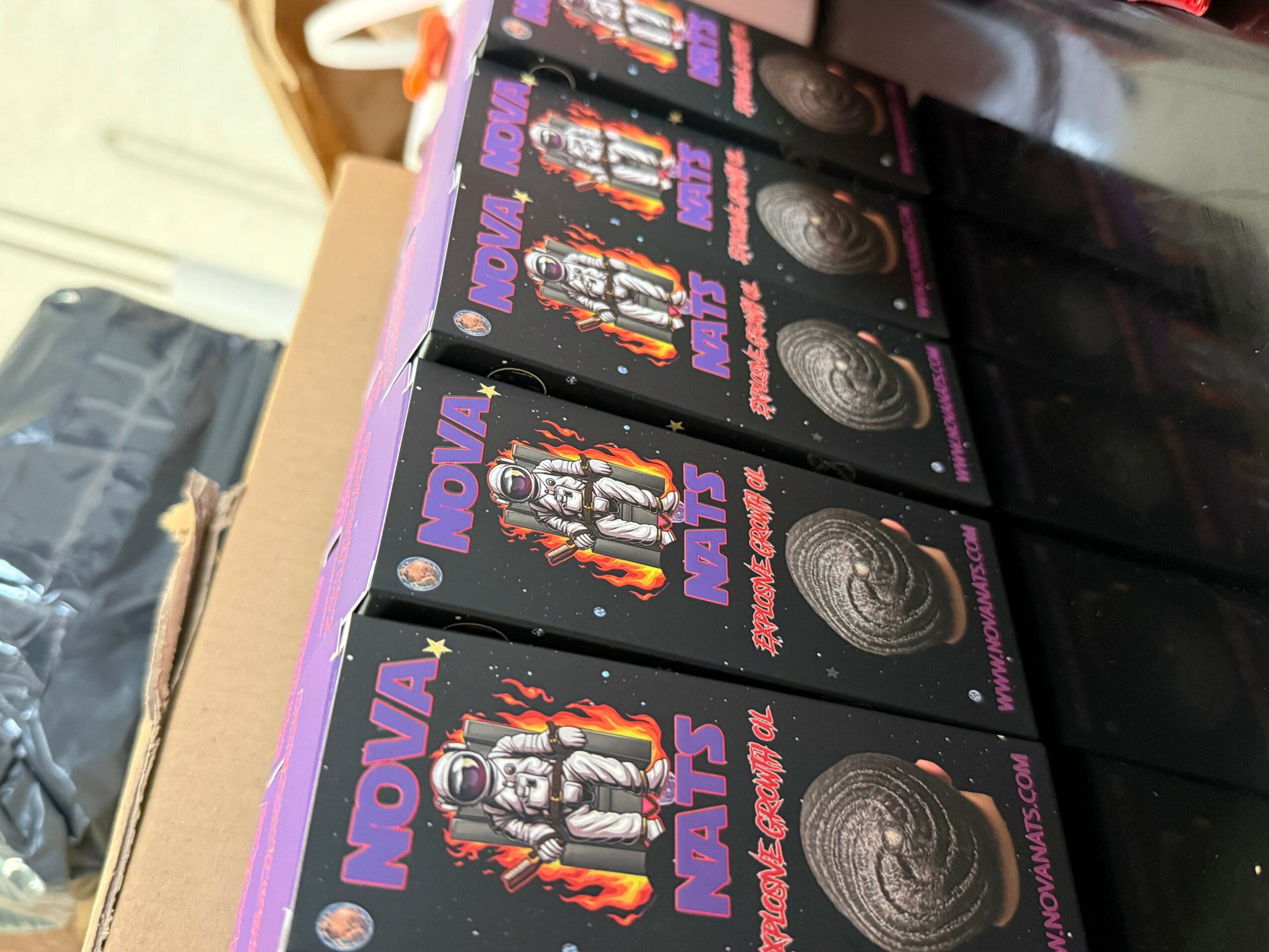 Stack of black boxes with purple and orange text and images of robots, placed on a black surface.