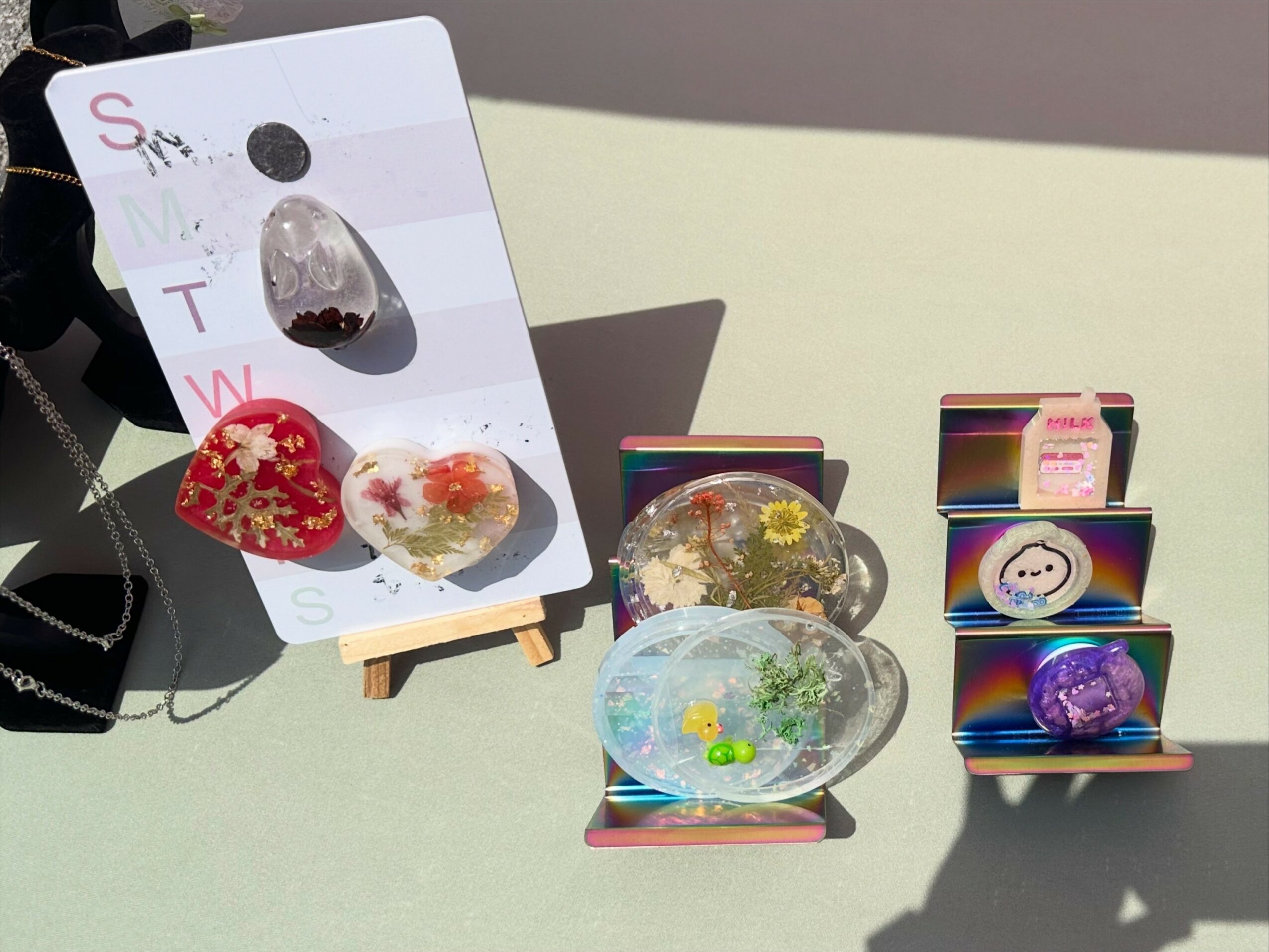 Display of decorative items including painted stones and small colorful objects on a table.