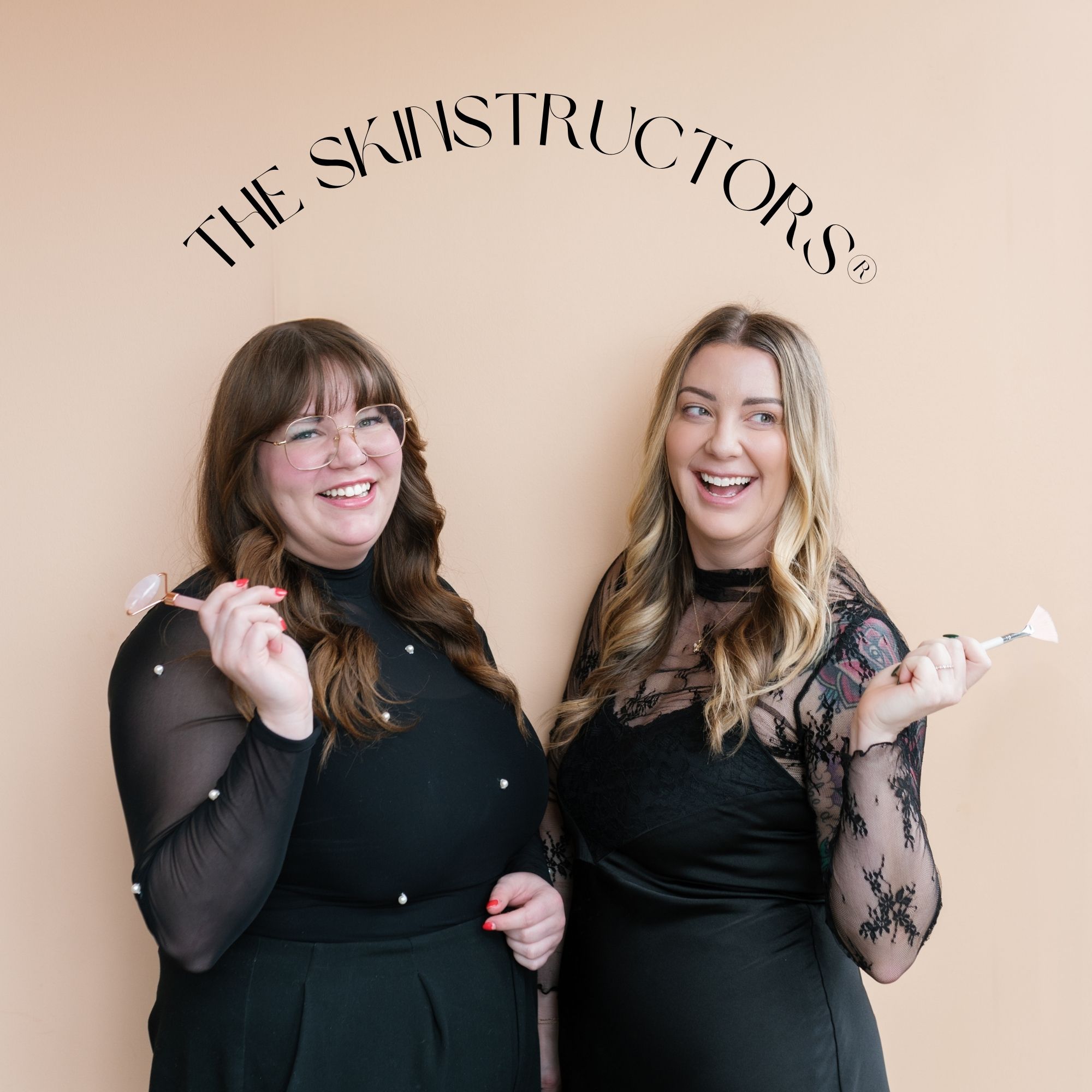 Two women smiling and holding spatulas in front of a wall with the text 'THE SKINSTRUCTORS'.