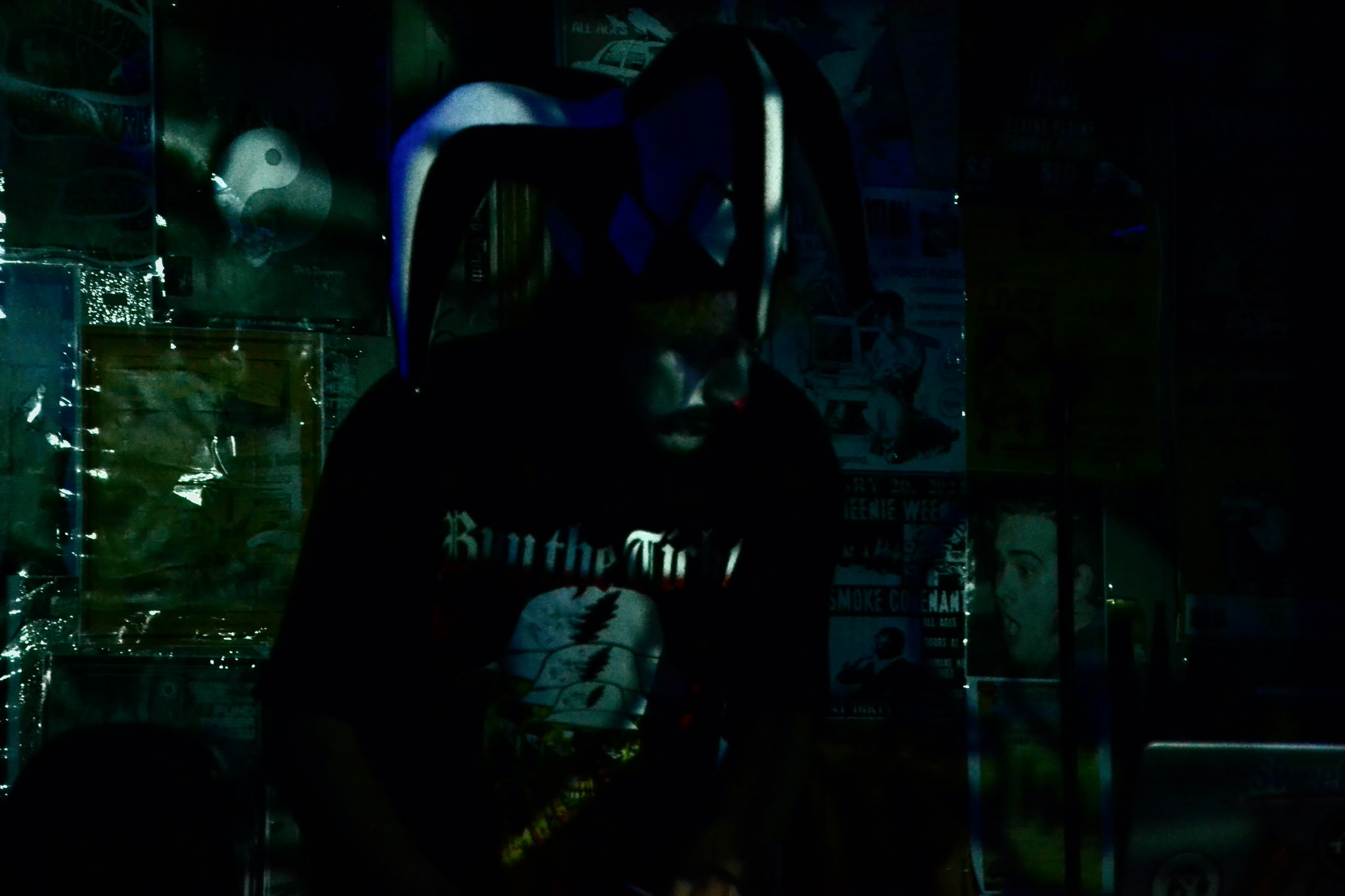 Dark image of a person with a helmet, partially visible, in a dimly lit environment.