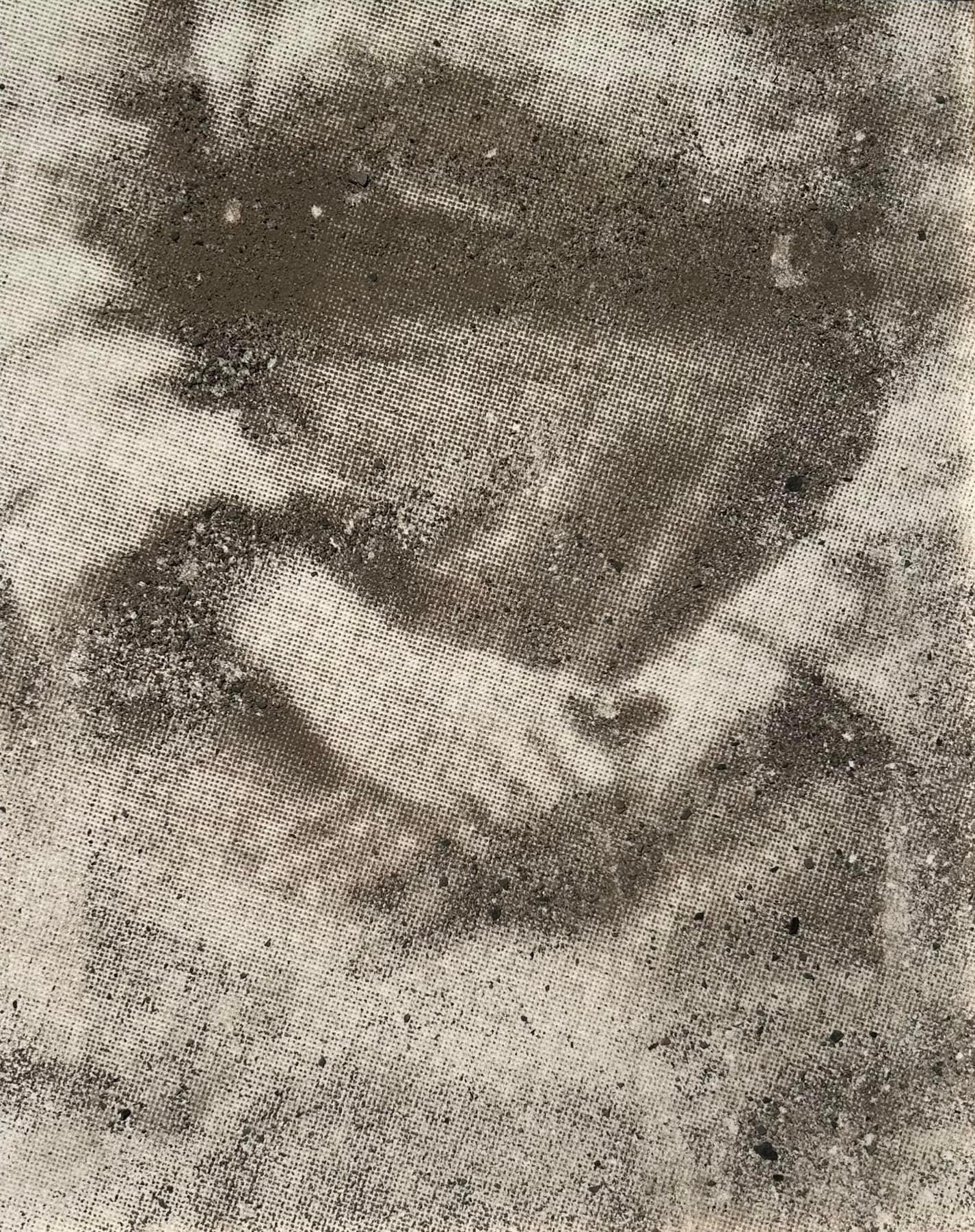 Person holding a book or paper, with a hand visible, in a grayscale image.
