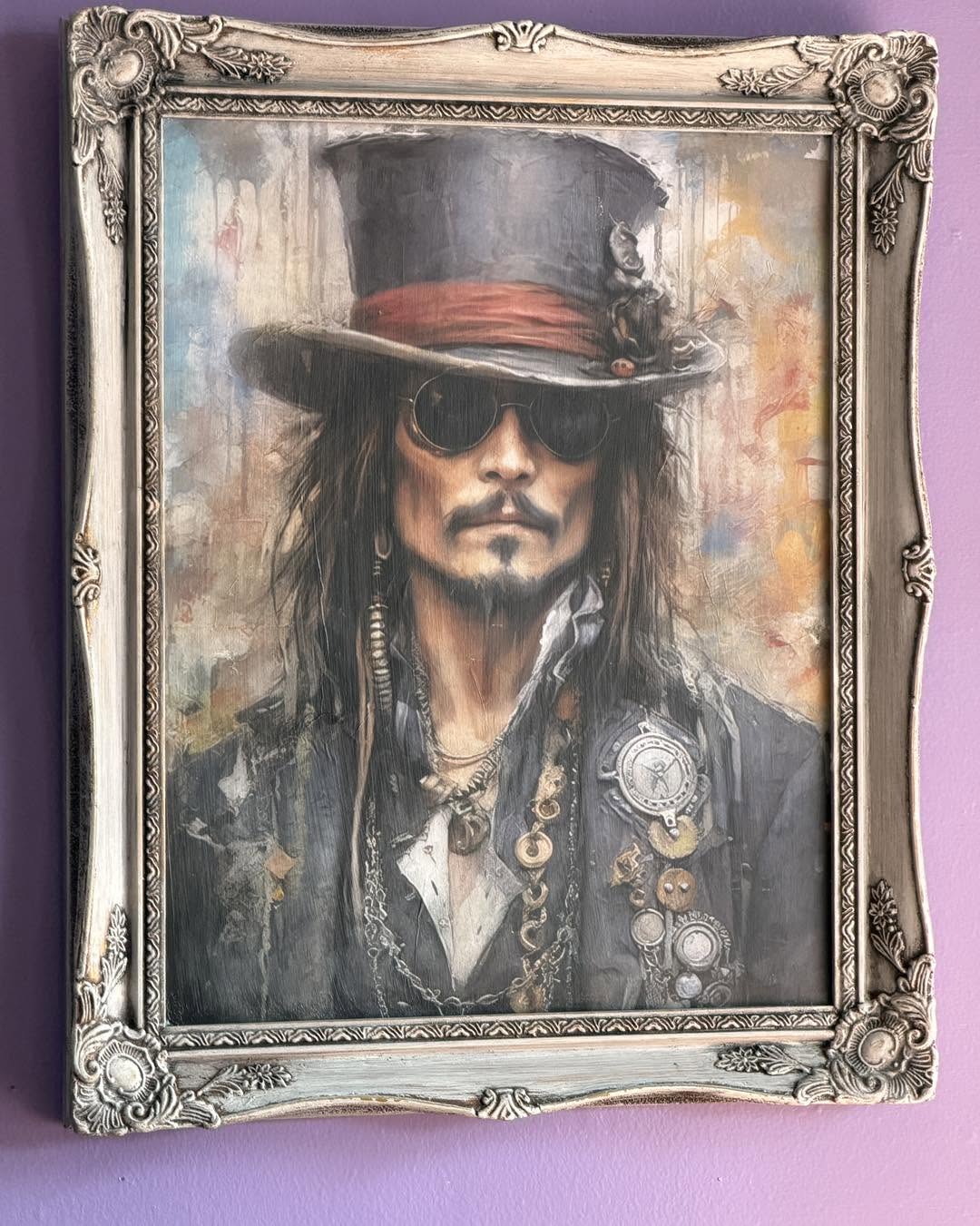 Portrait of a man with long hair, wearing sunglasses, a tall hat, and jewelry, in a decorative frame.