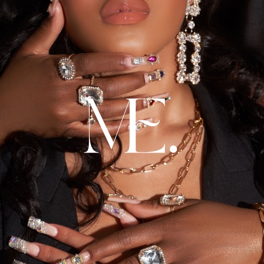 Close-up of a woman with jewelry, including rings, earrings, and necklaces, with her hand near her face and lips visible.