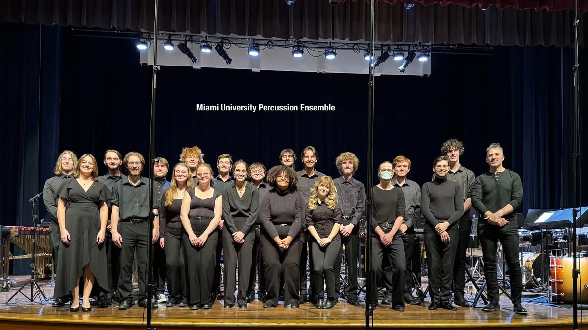 Group of people on stage with a sign reading 'Miami University Percussion Ensemble' behind them.
