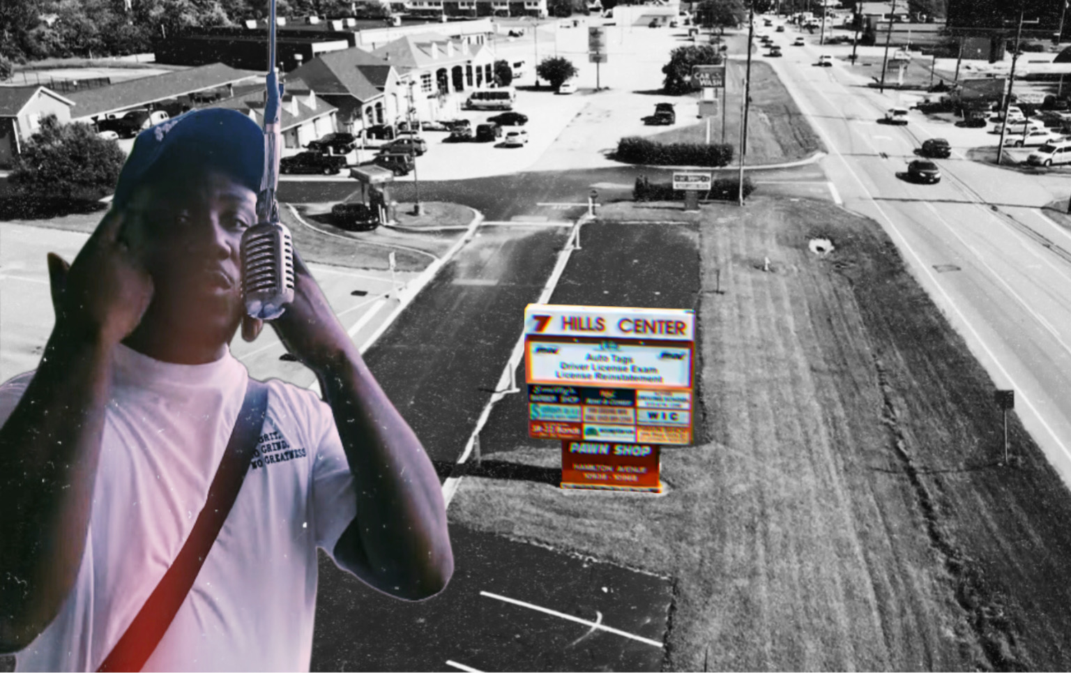 Person with a cap and shoulder bag standing in front of a parking lot with a Hills Center sign, black and white background.