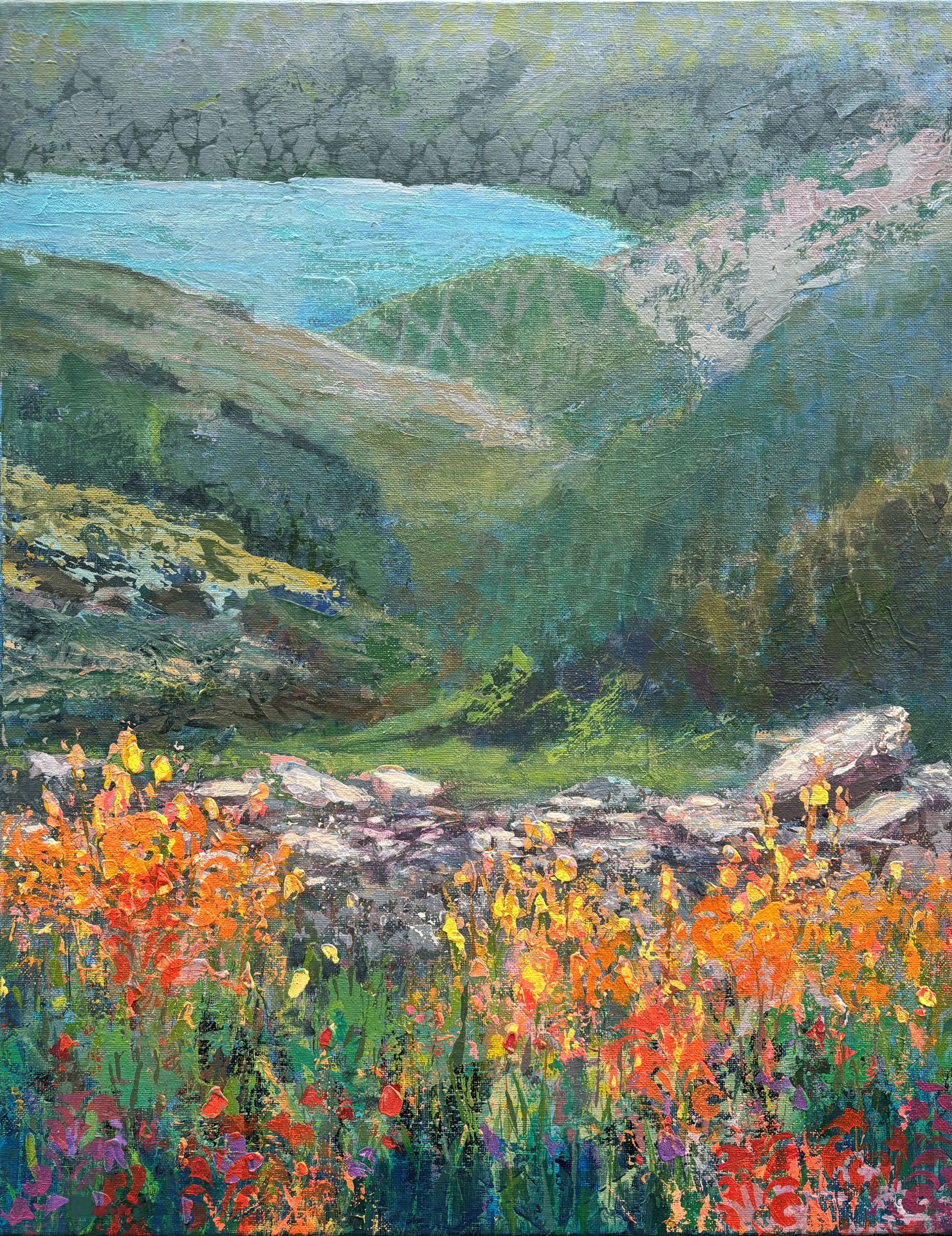 Landscape with colorful flowers in foreground, green hills, and a blue body of water in background.