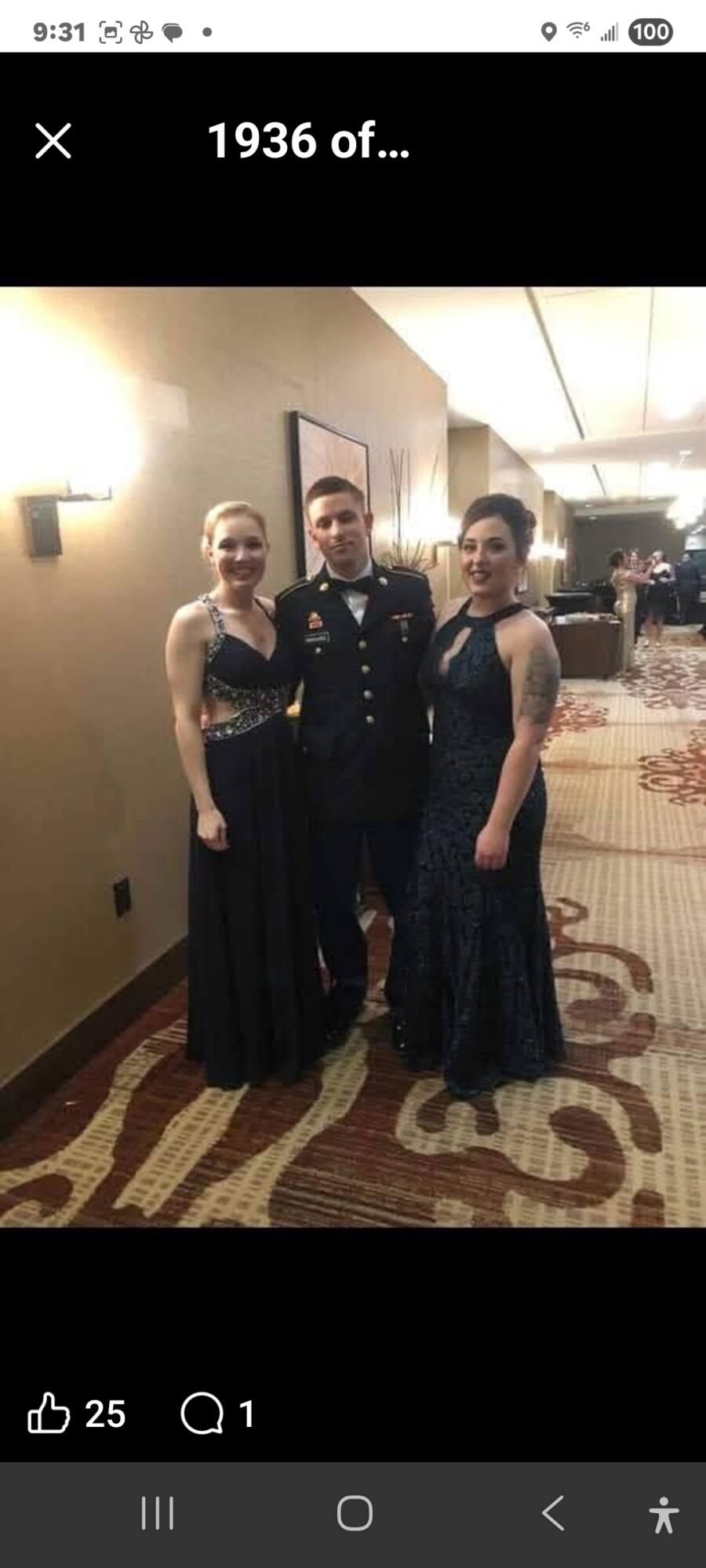 Three people in formal attire standing in a hotel hallway, two women in long dresses and a man in a suit, smiling.