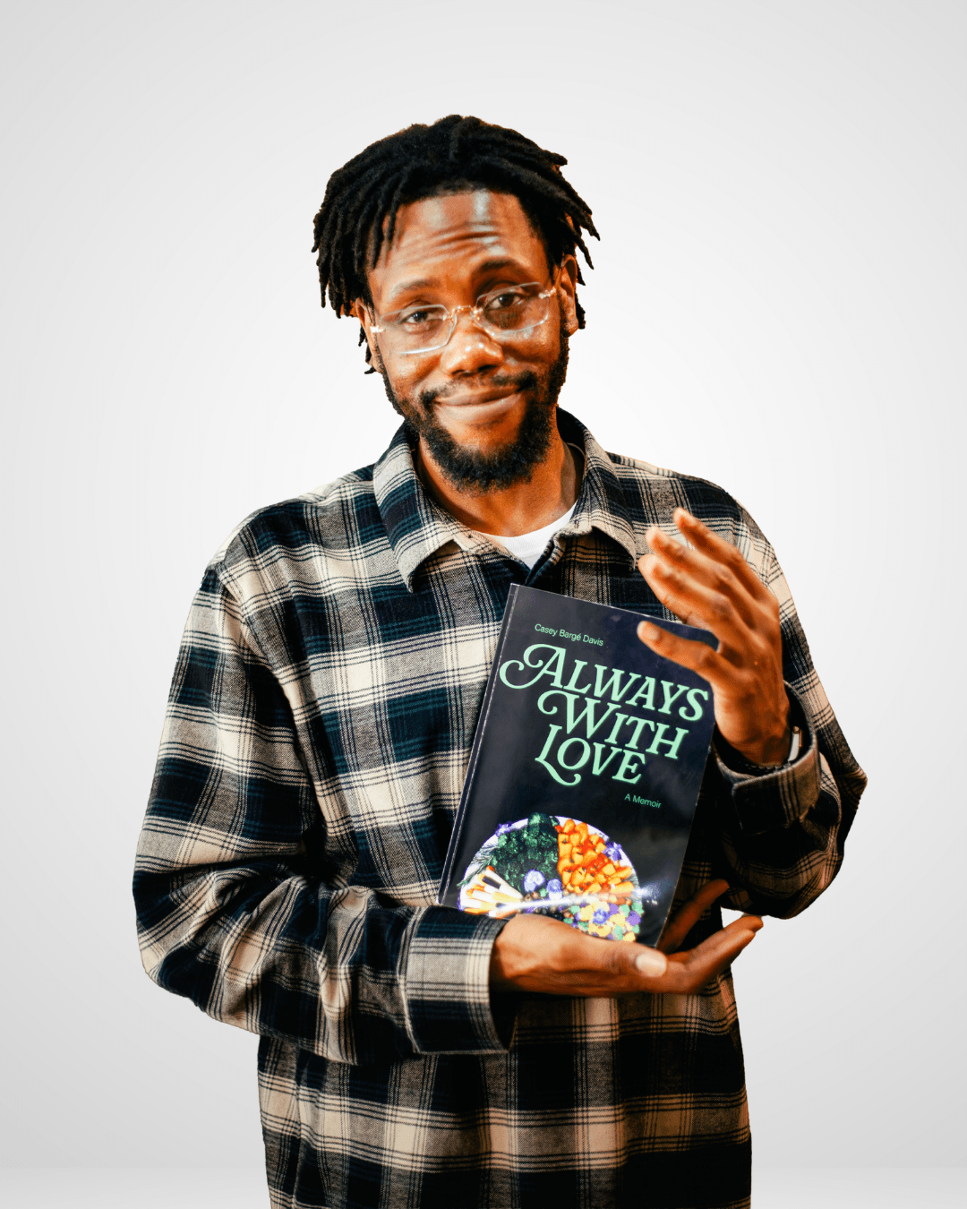 Man with glasses and dreadlocks holding a book titled 'Always with Love' against a plain background.