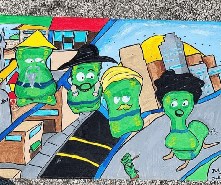 Four green-faced characters with exaggerated features and colorful clothing stand on a city street with buildings and a bridge in the background.