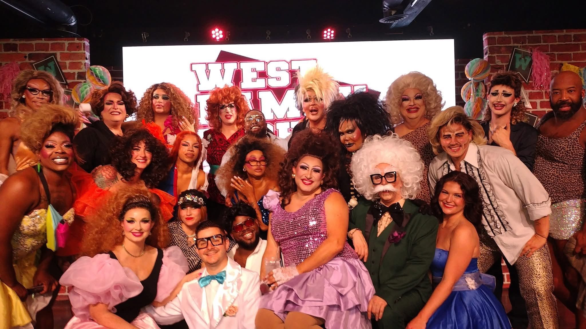 Group of diverse people on stage with a sign reading 'West End' in the background.