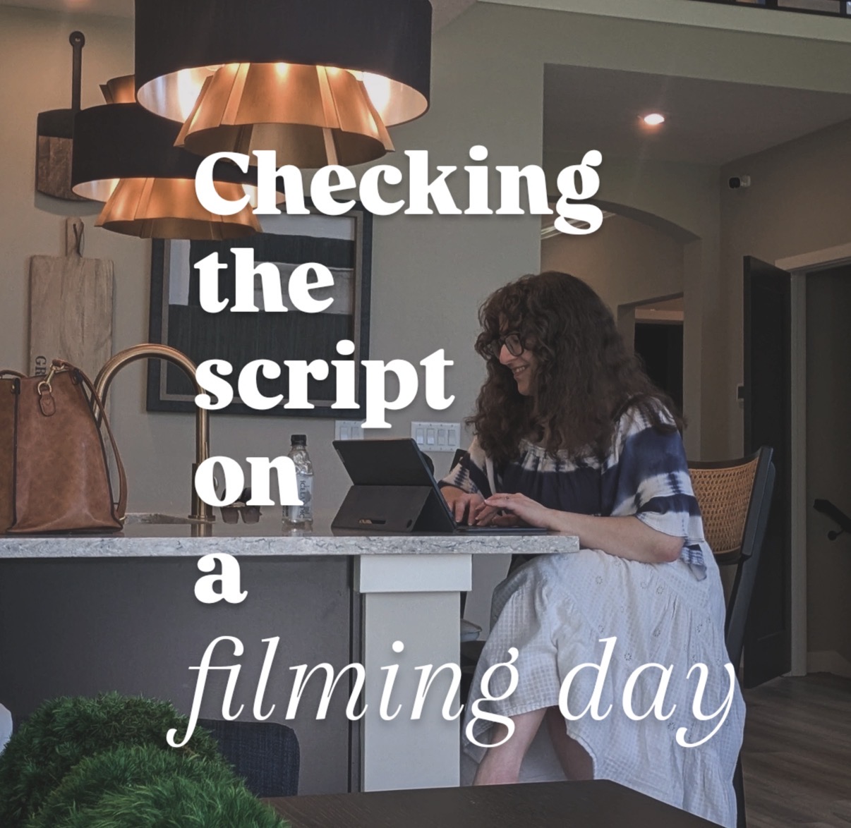 Woman with curly hair working on a laptop at a kitchen counter, with text overlay about filming day.