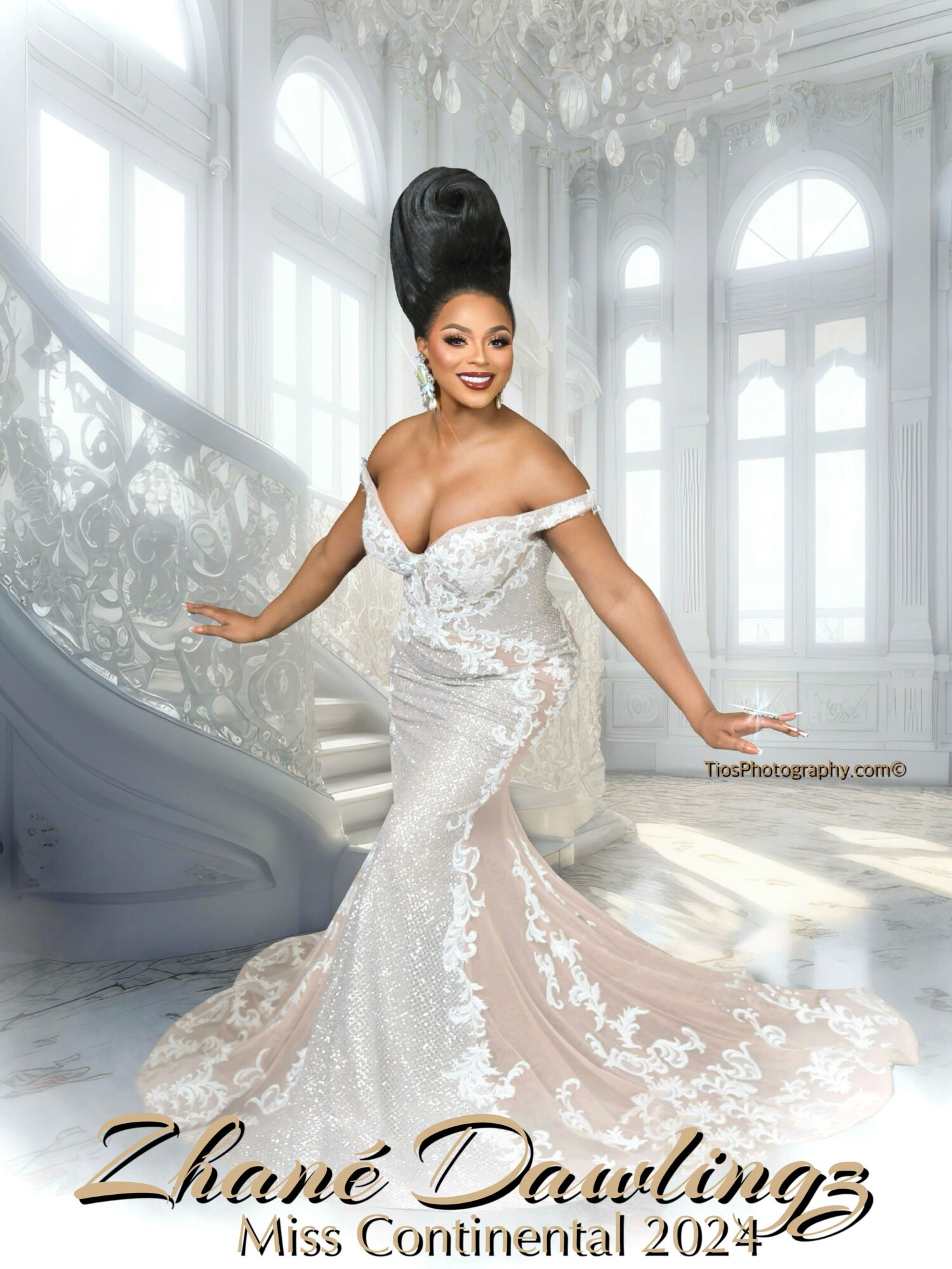 A woman in a white wedding gown with lace details stands in a grand, bright interior with large windows and a staircase.
