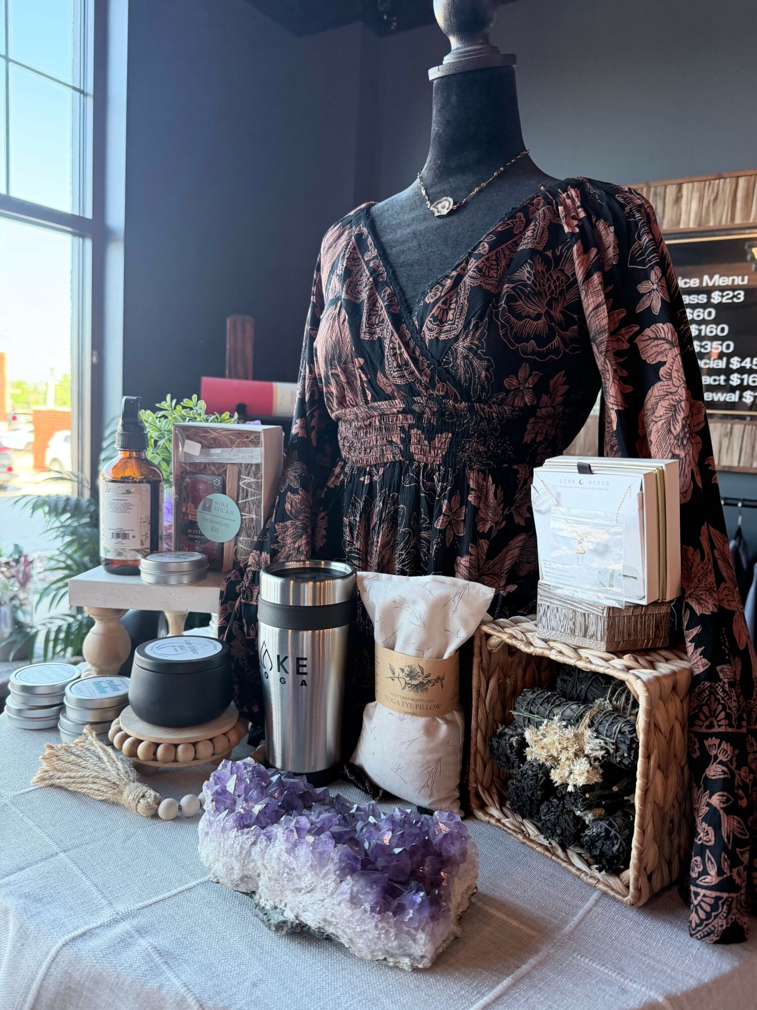 Display of crystals, books, and decorative items on a table with a window in the background.