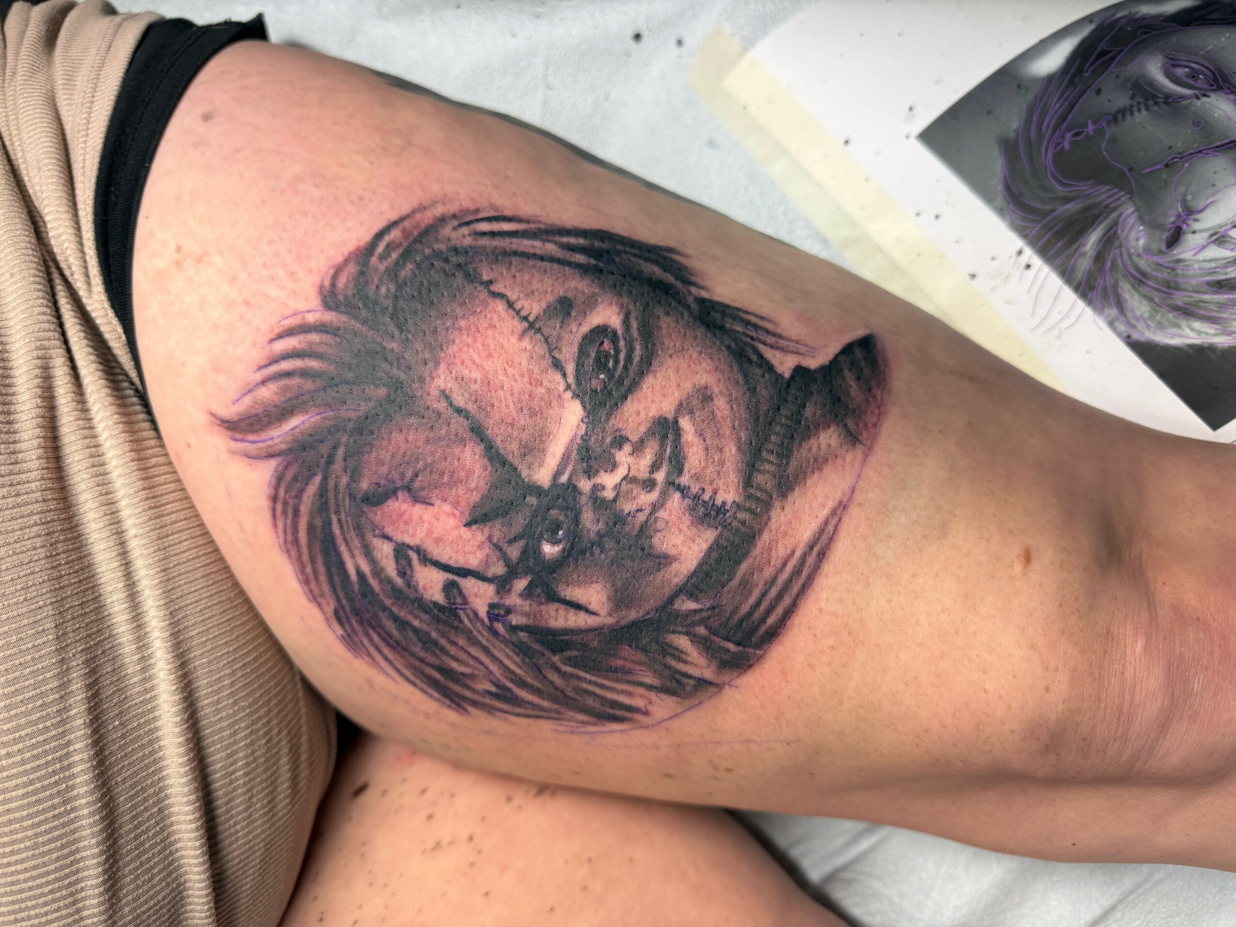 Tattoo of a horse's head with flowing mane on person's upper arm, black and gray shading, realistic style.