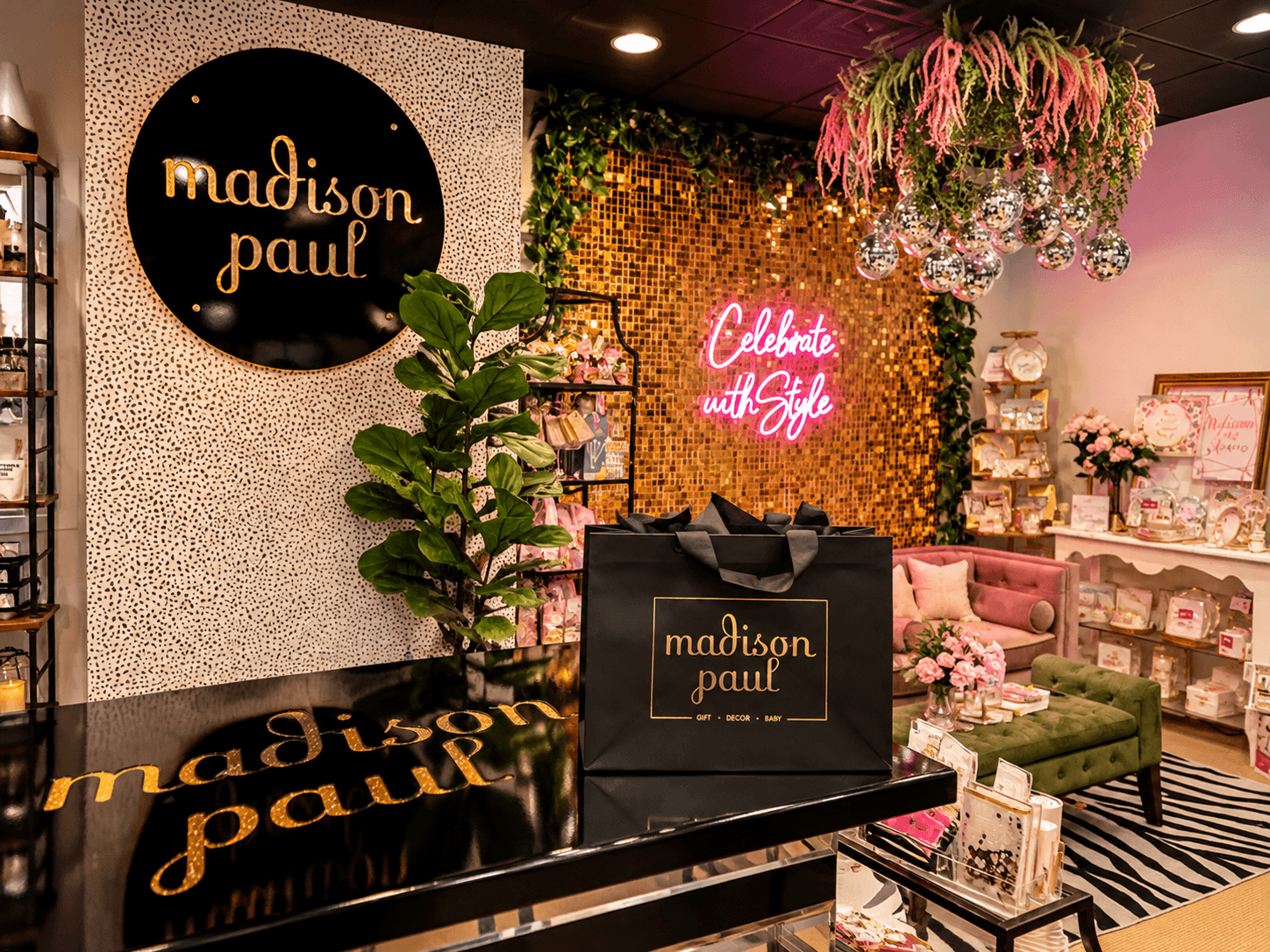 Boutique interior with a black-and-gold Madison Paul sign, floral displays, a counter, and seating area.